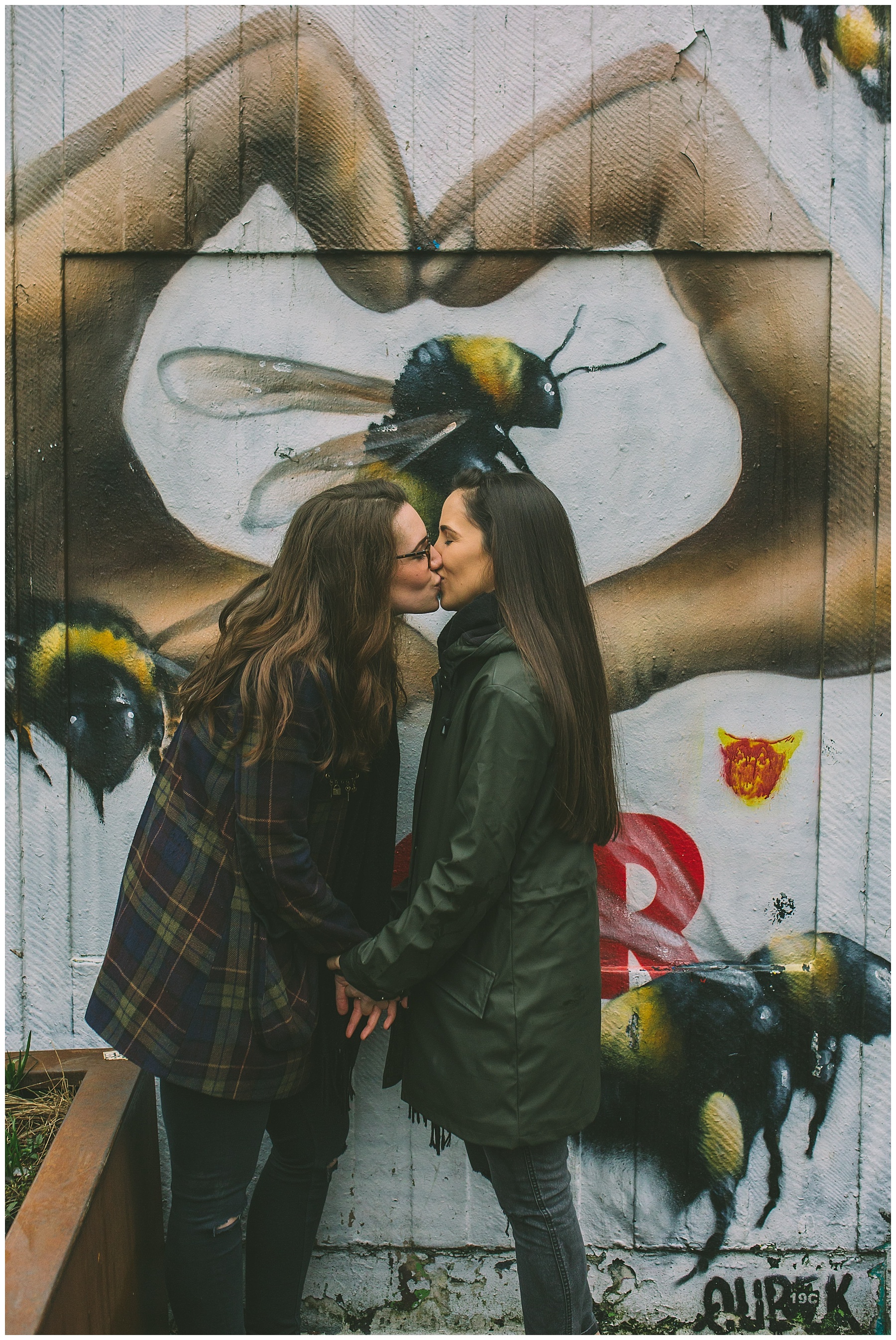 Couple share a kiss in front of iconic Manchester bee graffiti