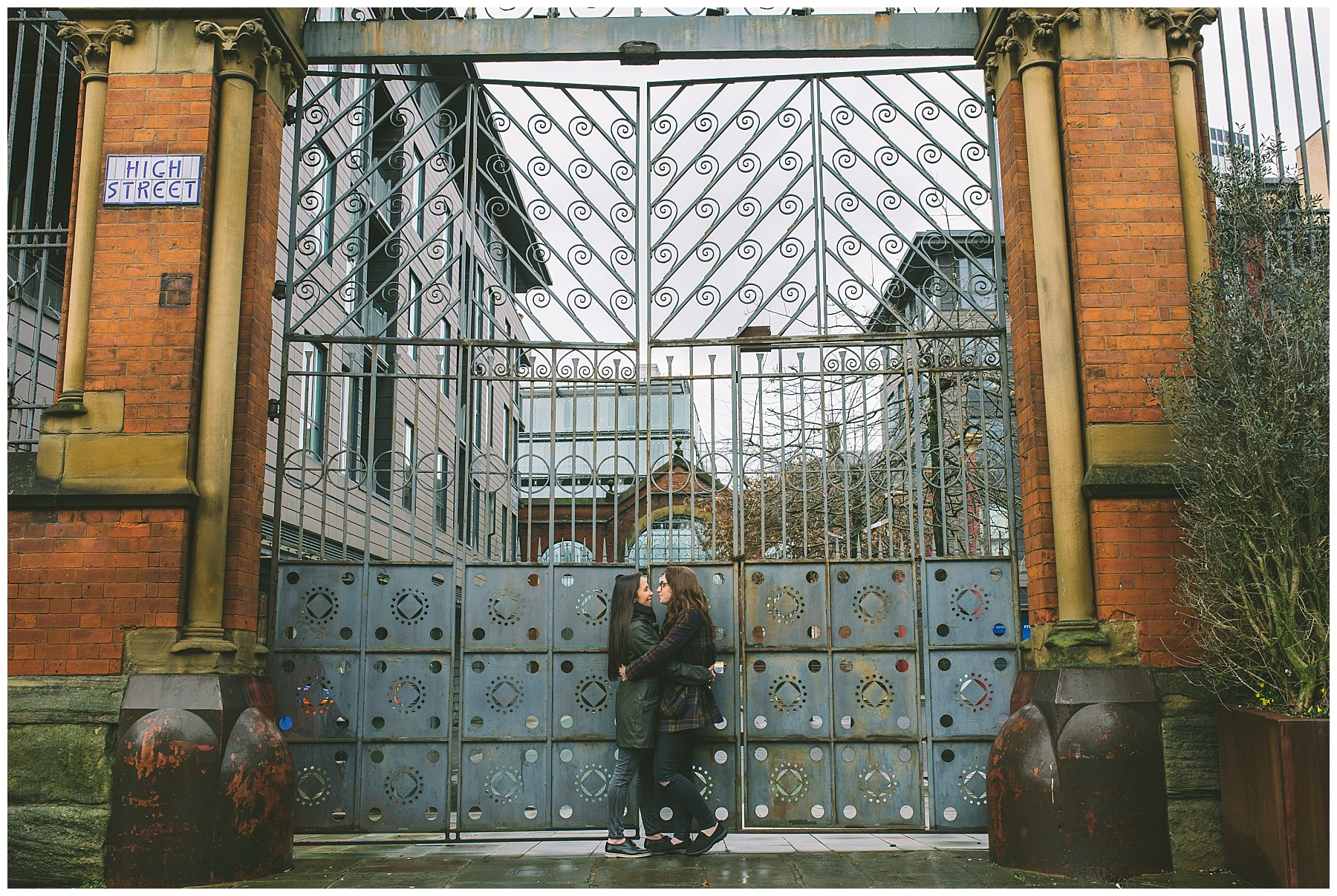 lesbian couple share a moment in front of the gates of the old Manchester fish markets