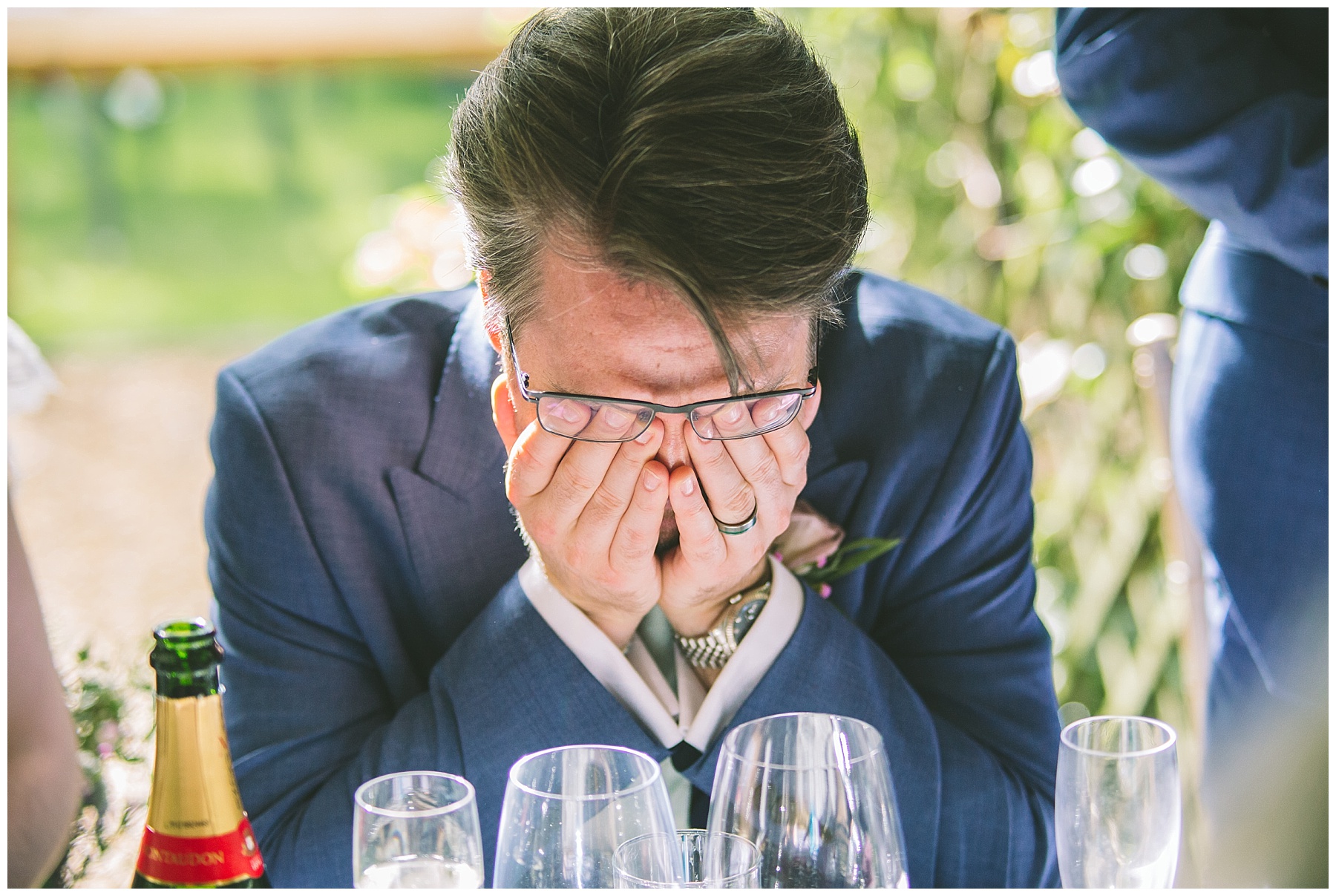 groom with his head in his hands in reaction to the best mans speech
