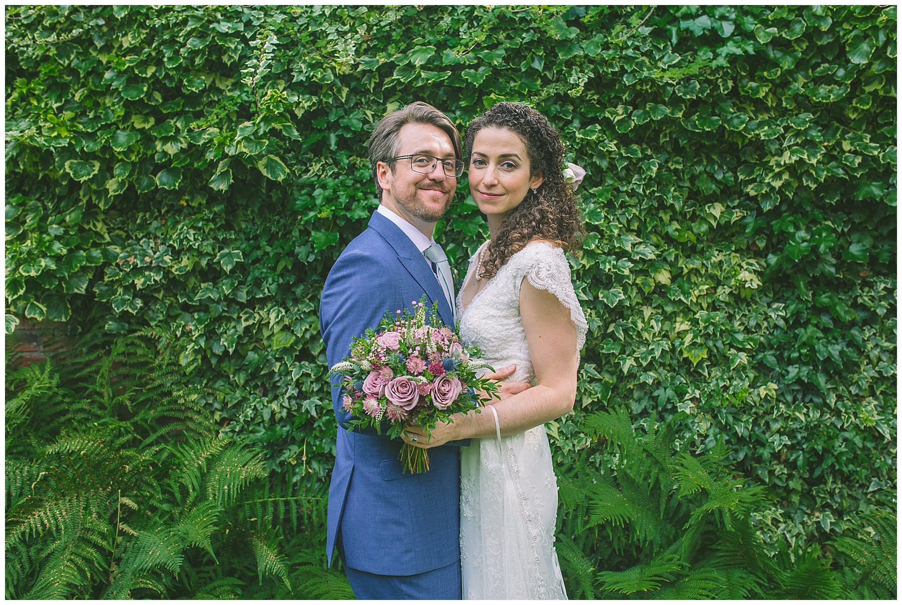 married couple in front of all the greenery in the gardens of Eleven Didsbury Park