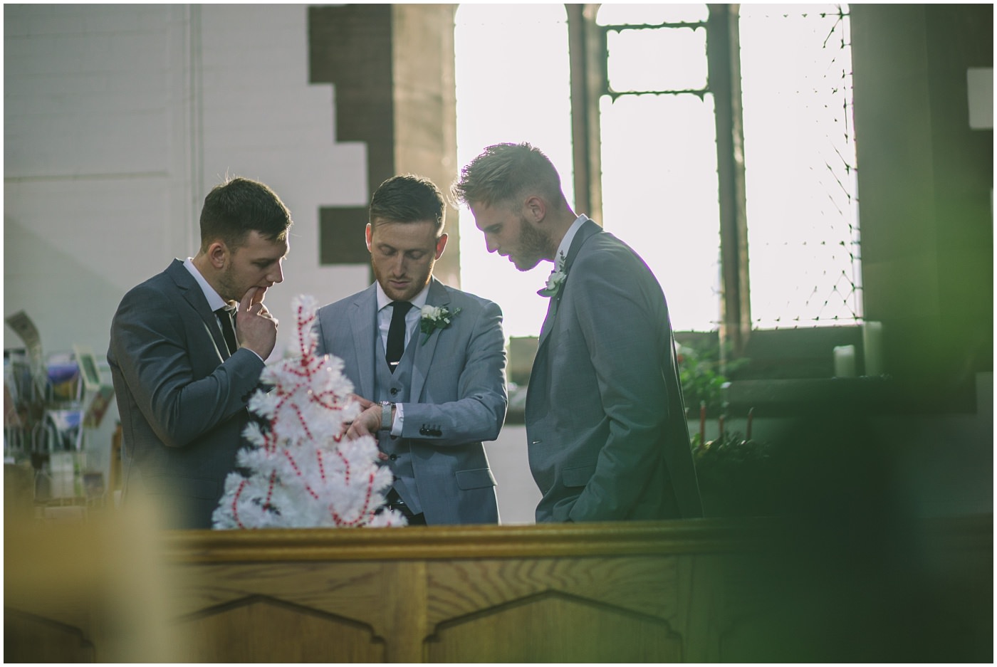 Groom checks his watch at church as he waits for his bride