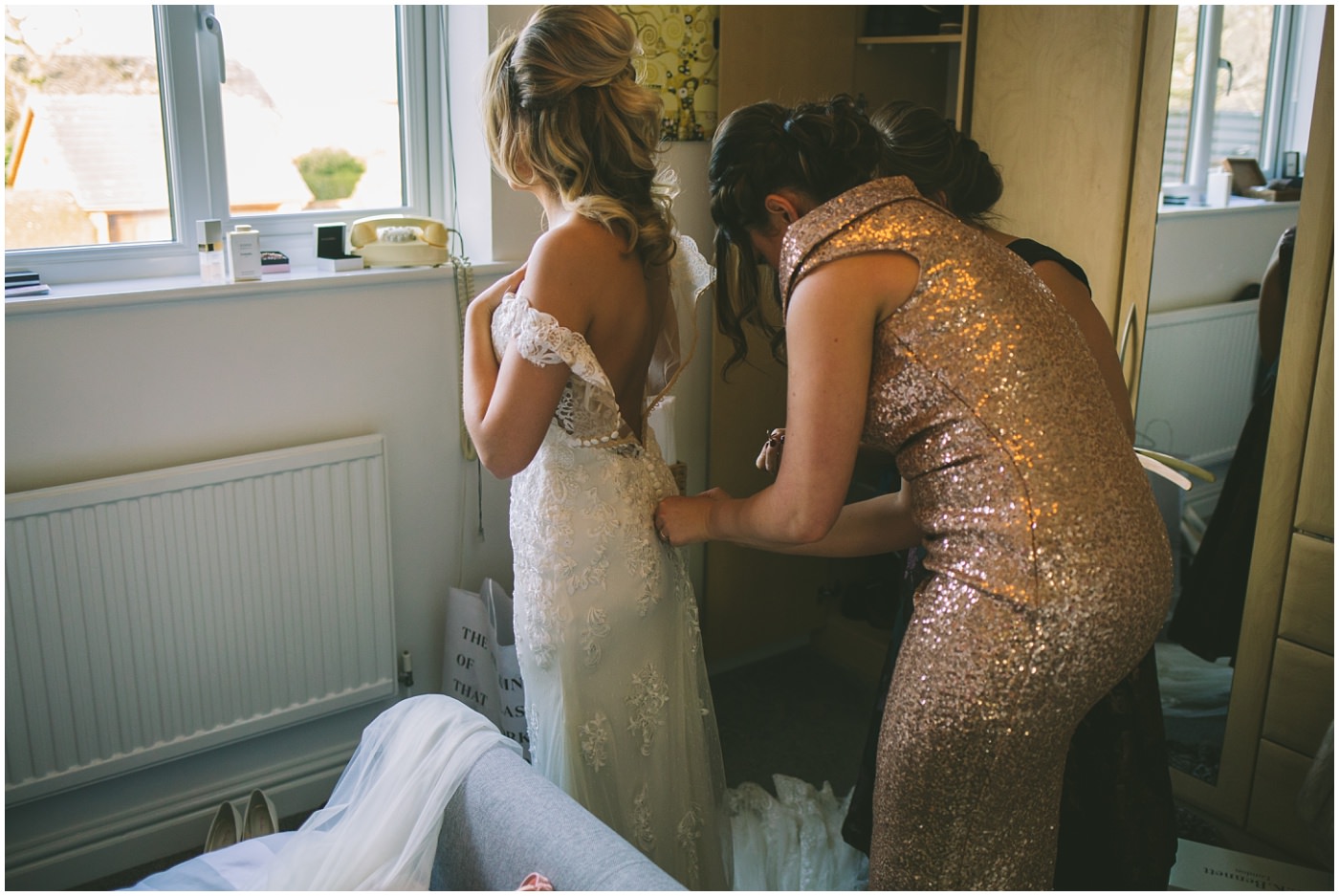bridesmaids assist becca into her wedding dress for her pryors hayes wedding