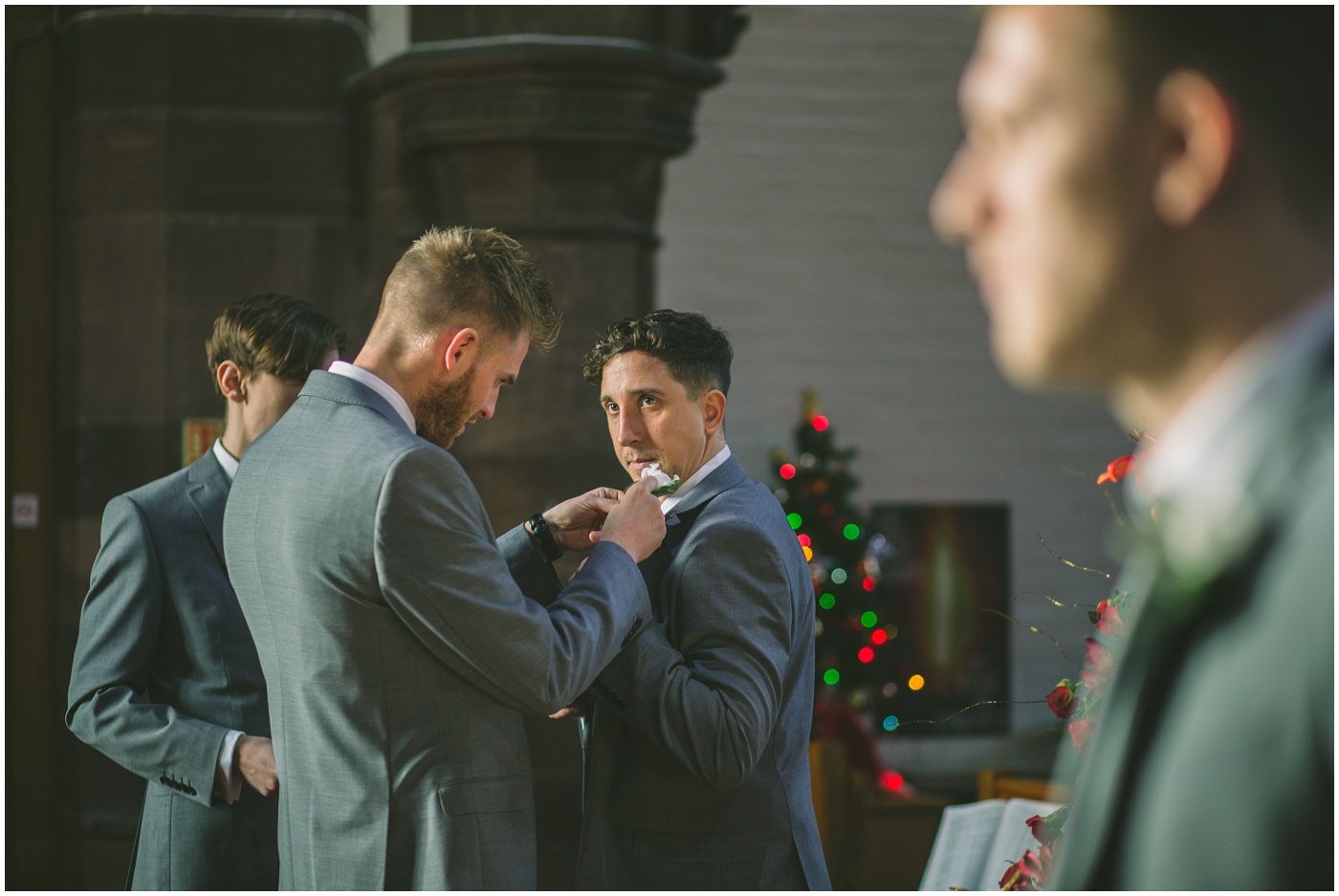 best man applies buttonhole for groomsman