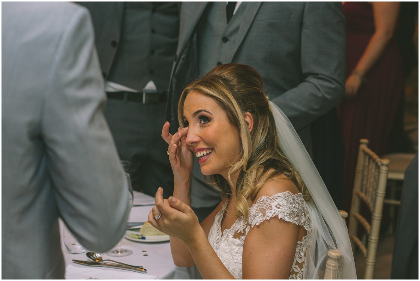 bride wipes away a tear during her husbands speech