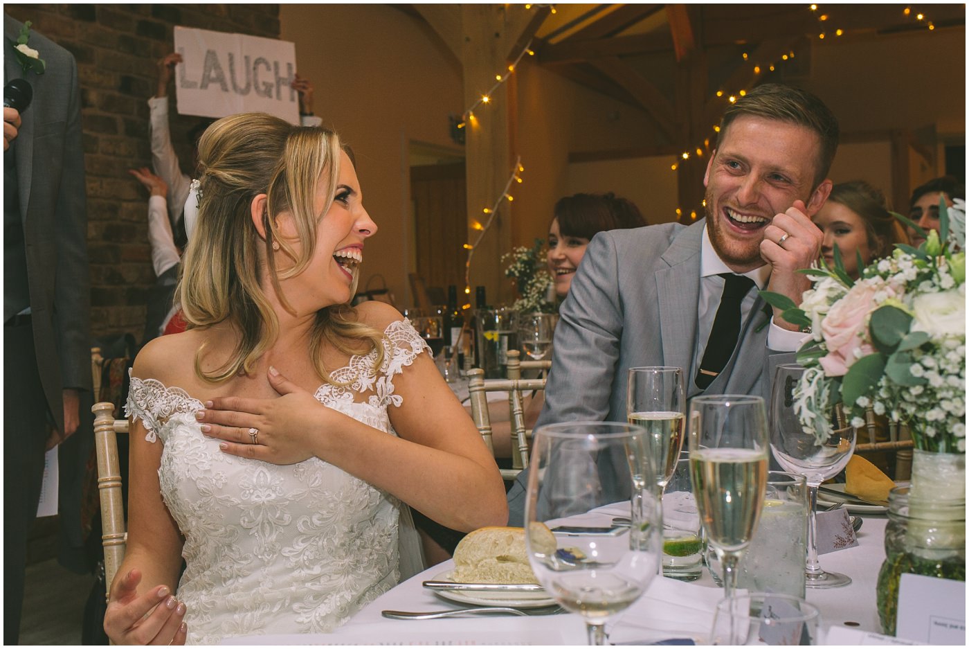 bride and groom laugh at best mans speech
