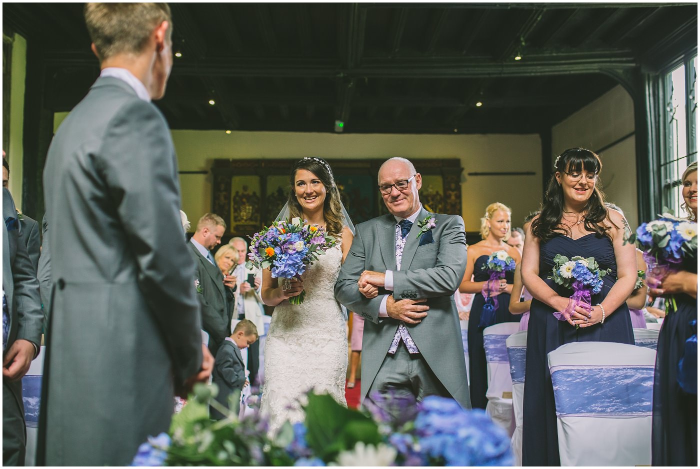 Bride smiles as she is walked down the isle by her dad