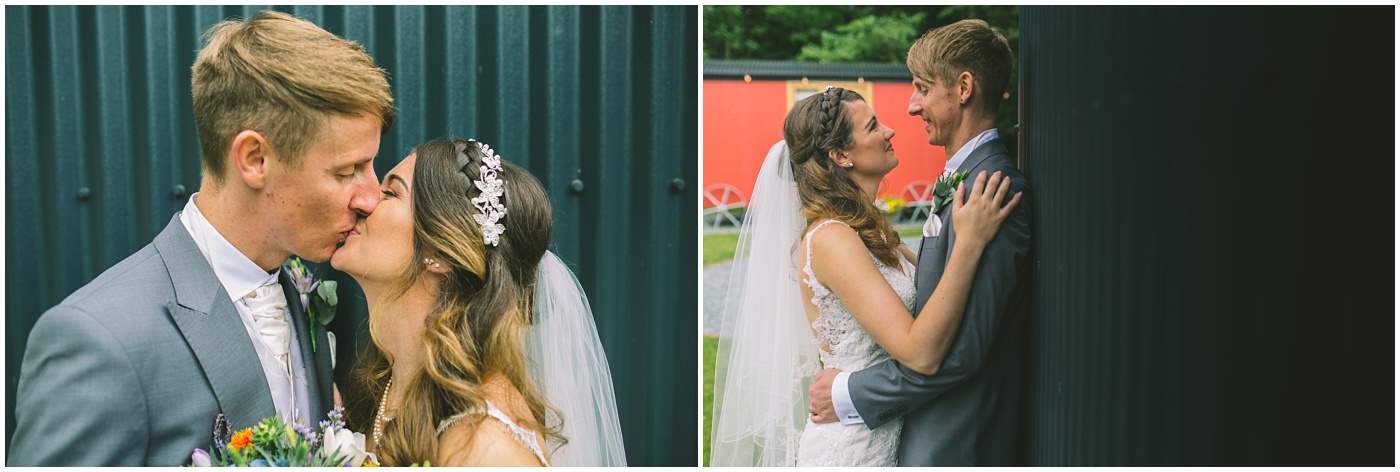 married couple share a kiss by the shepherds huts at samlesbury hall
