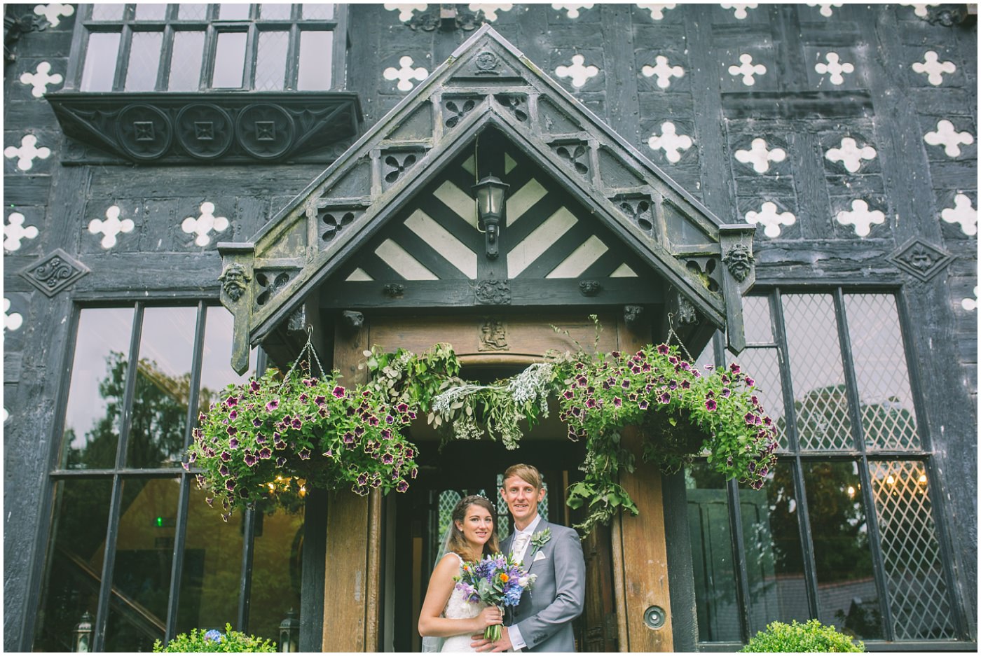 Newly married couple stand for portraits outside the front of Samlesbury Hall