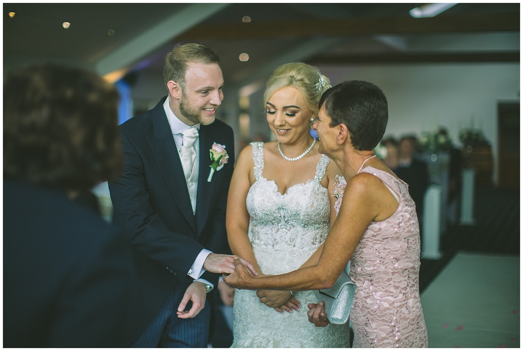 mother of the bride offers daughters hand to groom