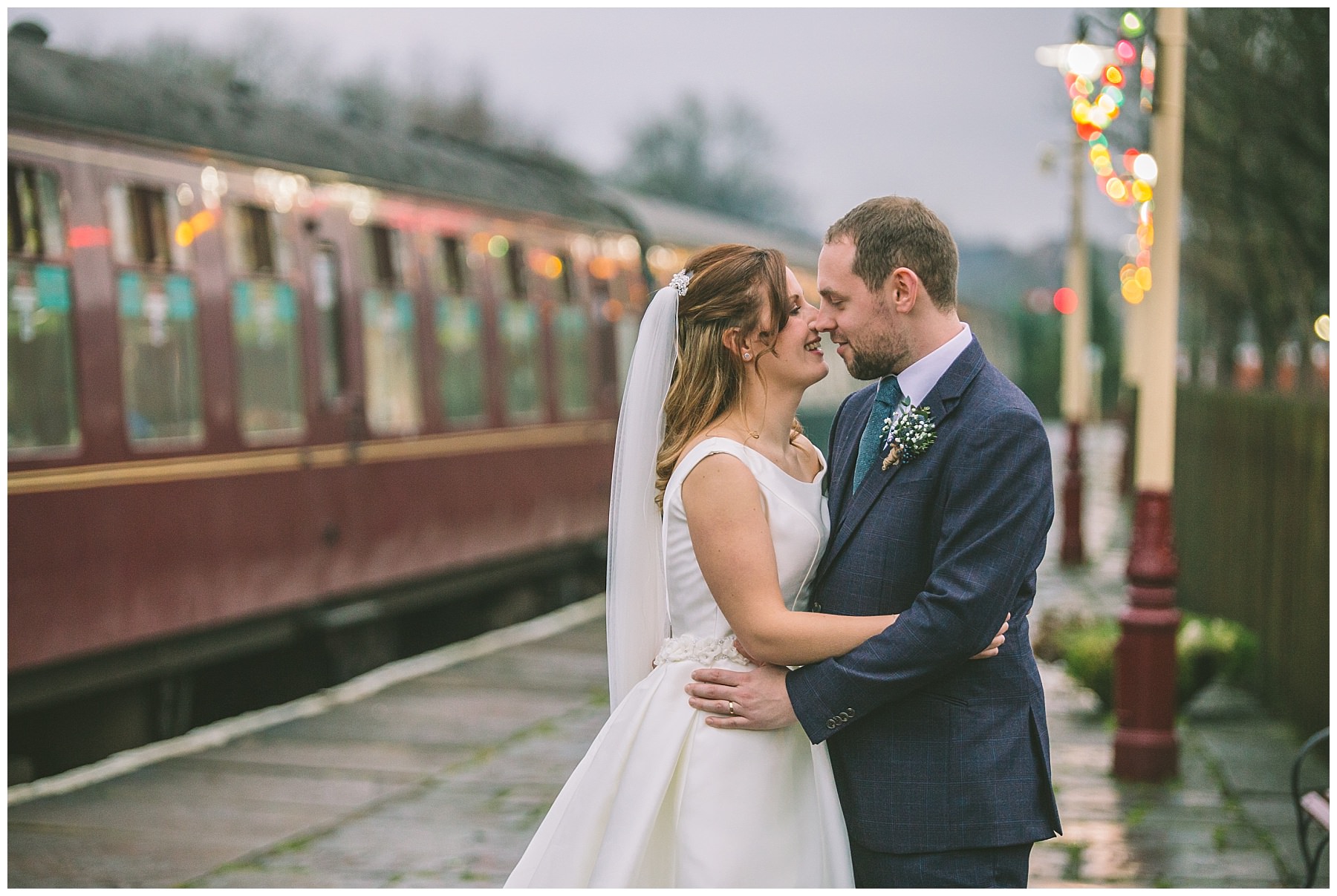 Wedding couple stand on steam rail platform