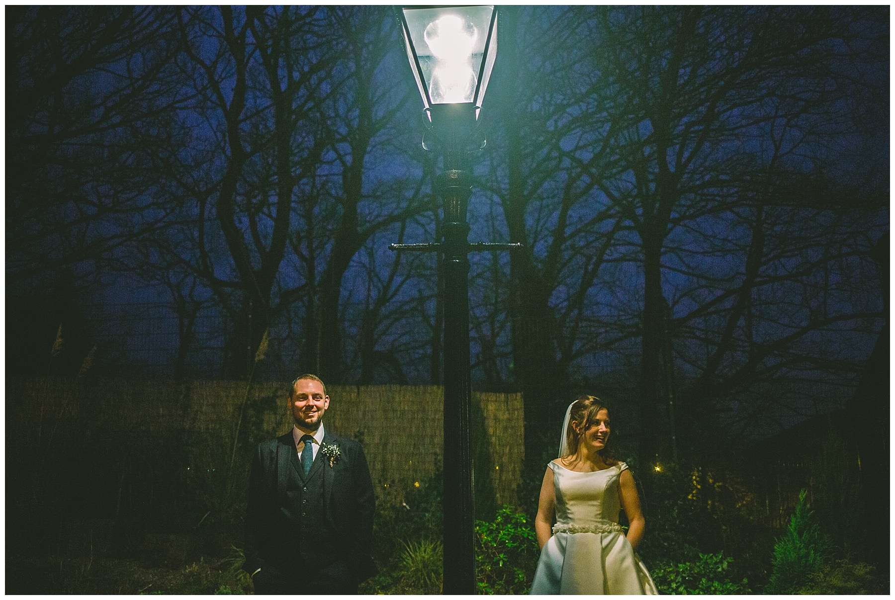 Couple stand cool under victorian street lamp for wedding portraits