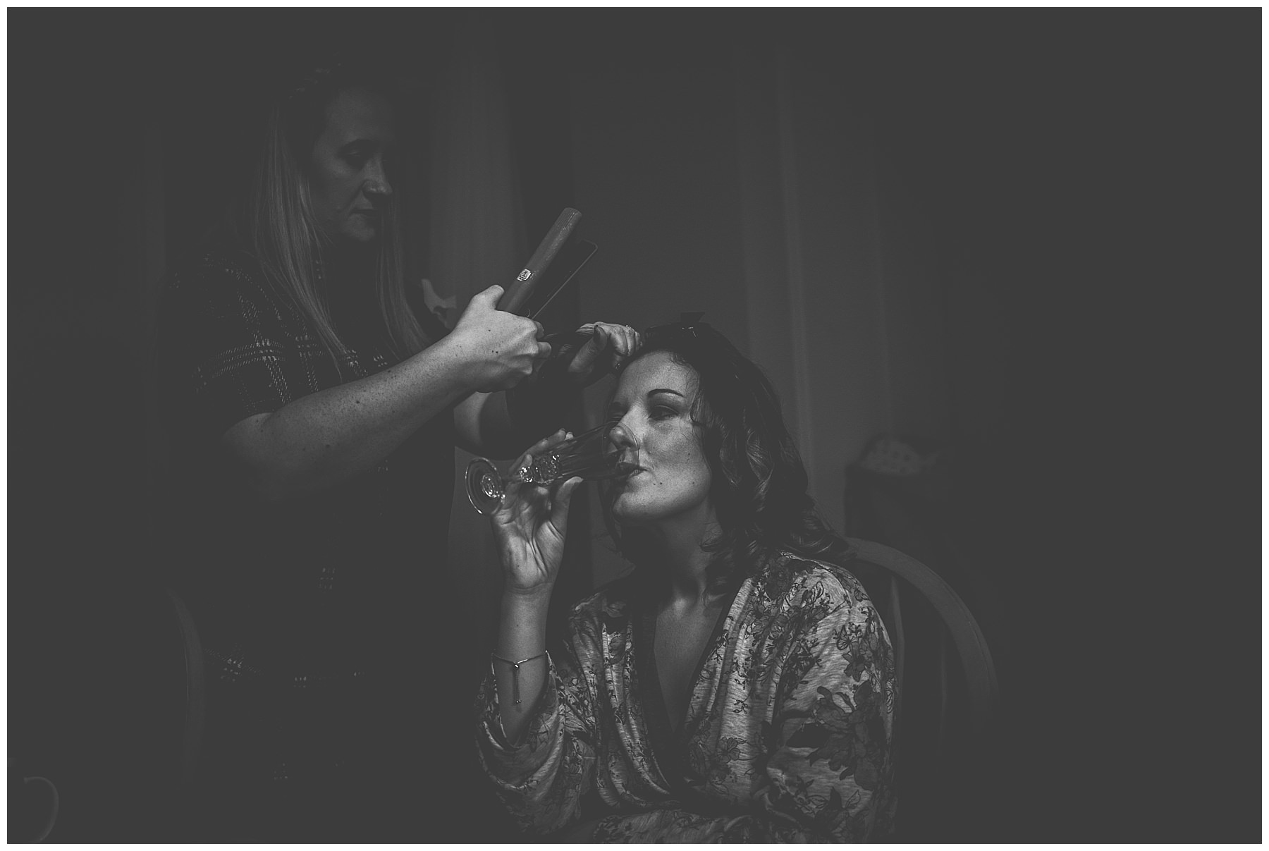 Black and white shot of bride having her hair done for her wedding