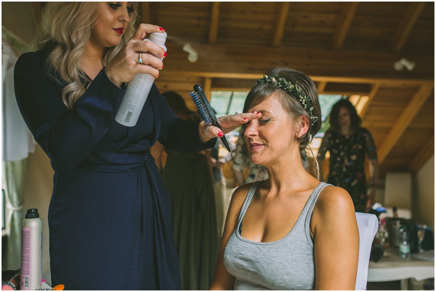Bride has her hair sprayed by hairdresser