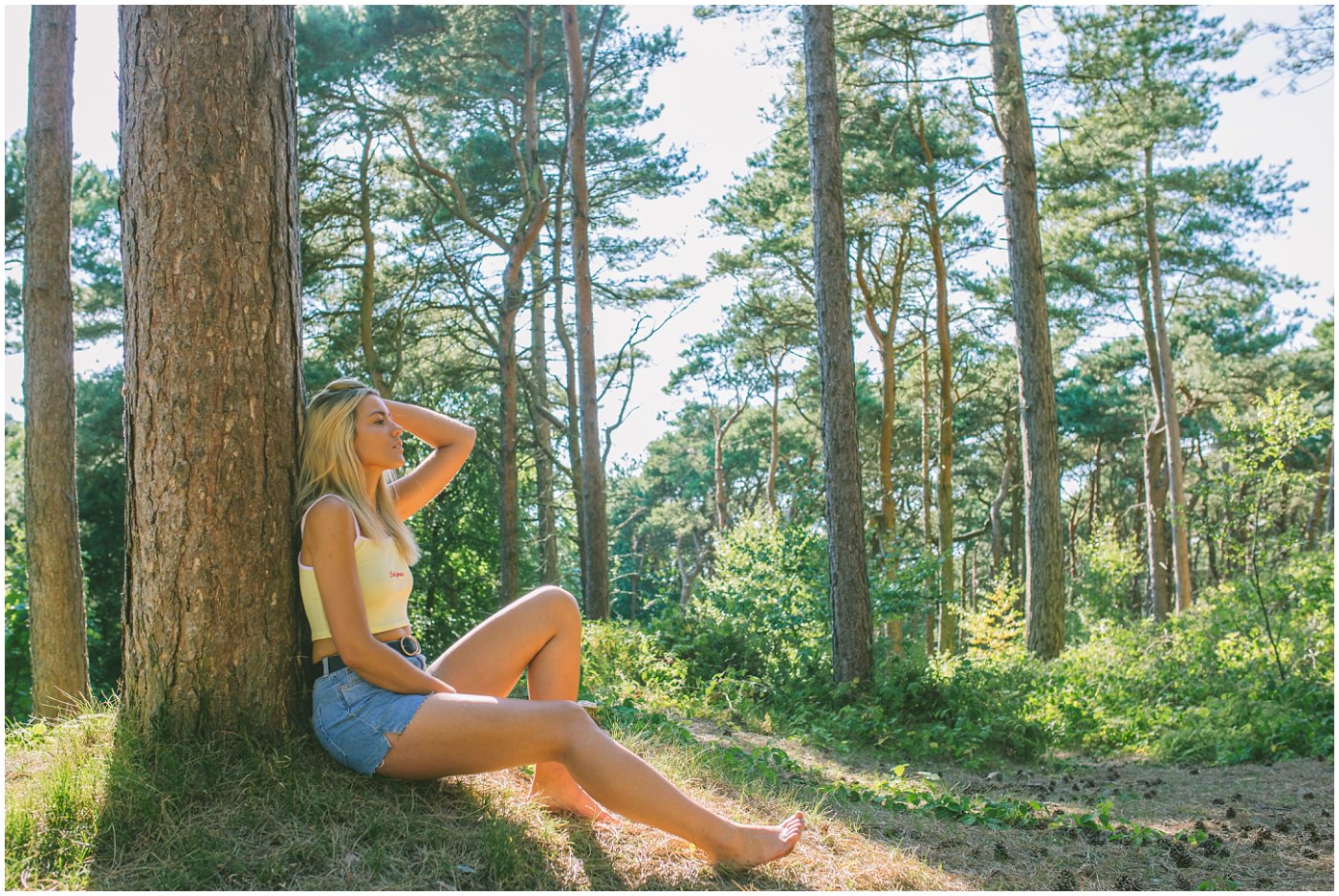 model sits in the sun against a tree at formby