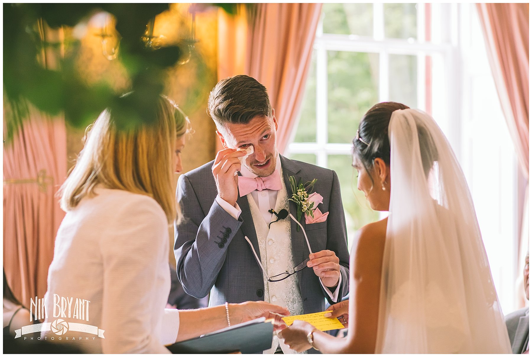 groom wipes a tear from his eye during wedding ceremony