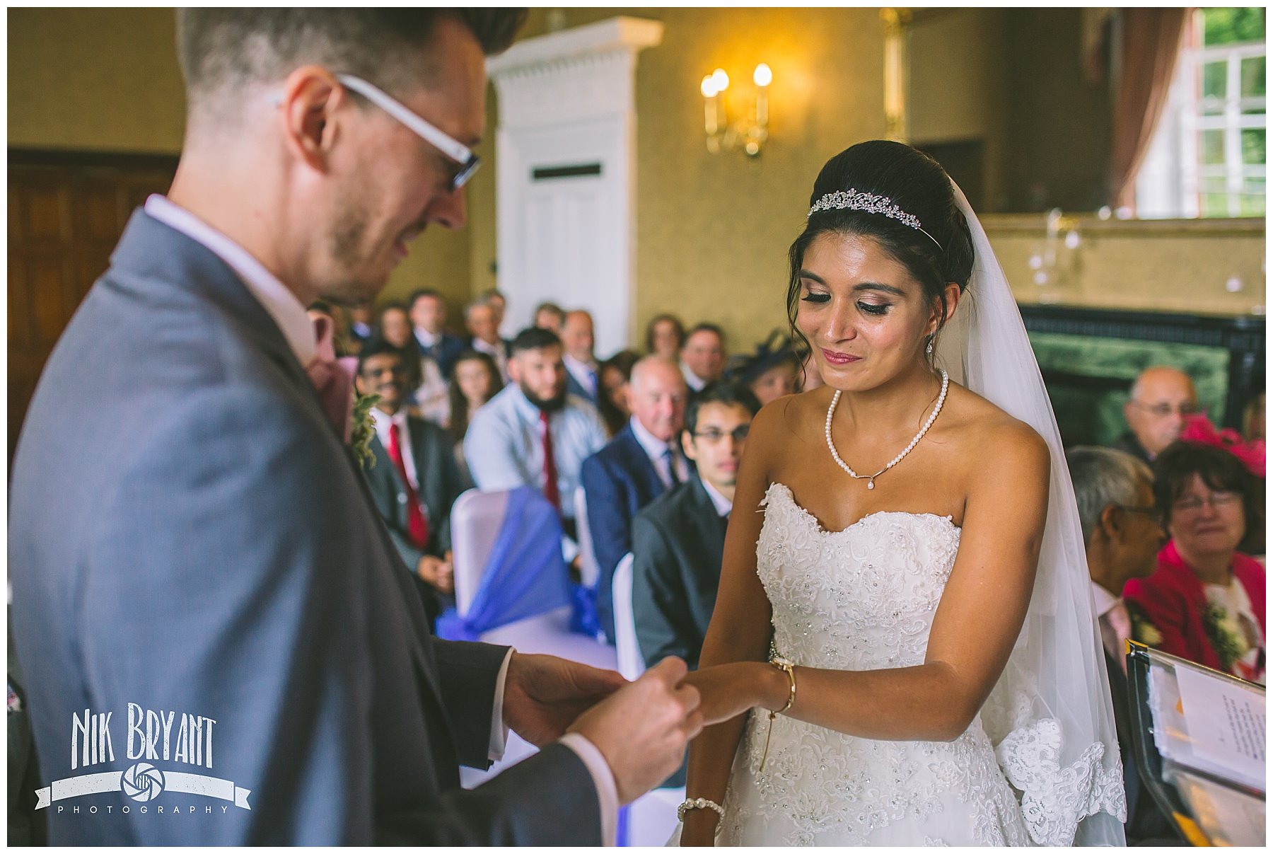 Bride and groom exchange rings during wedding ceremony