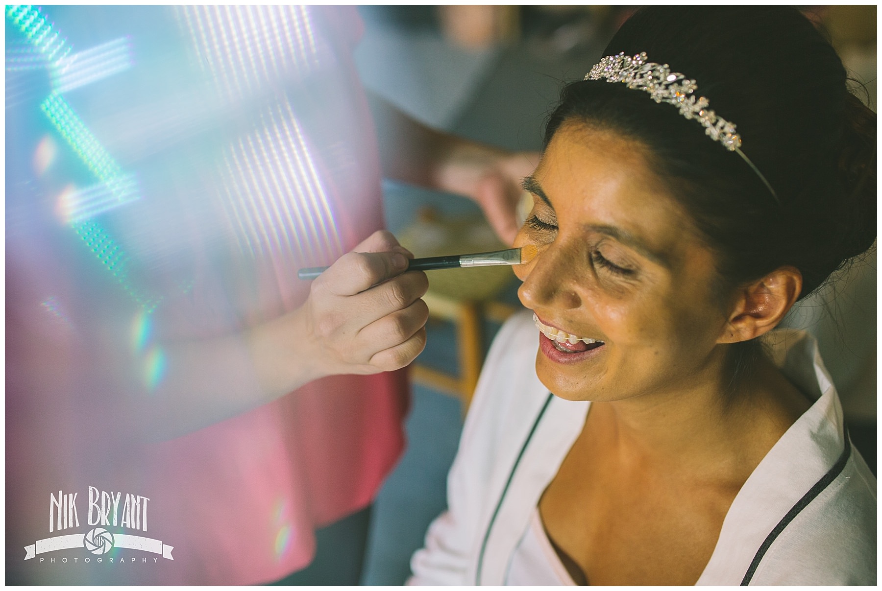 Bride to be laughs as make up is applied