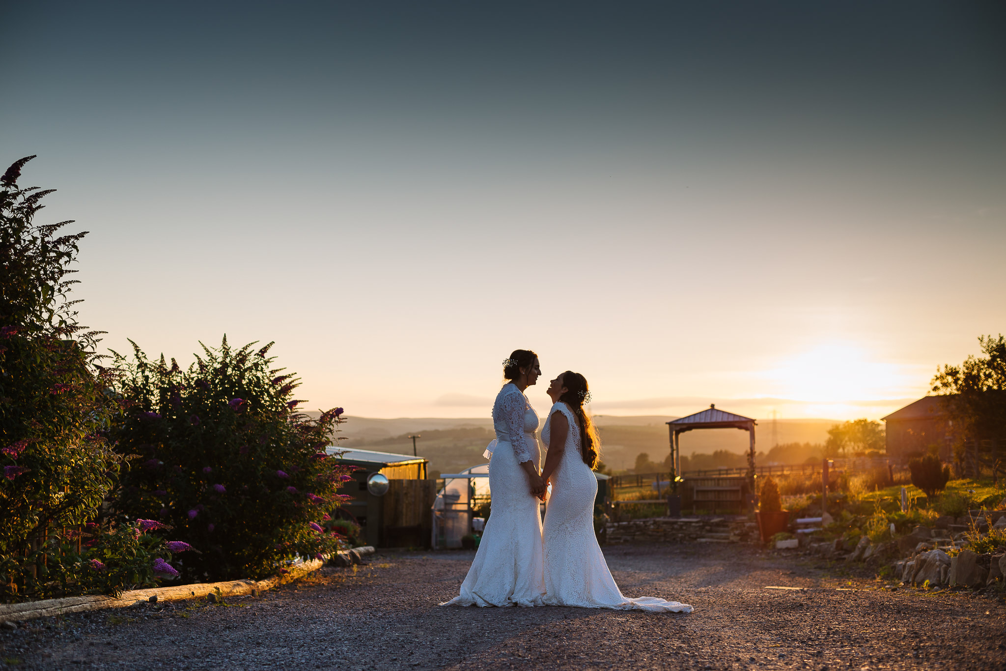 Two brides enjoy sunset at the wellbeing farm same sex wedding