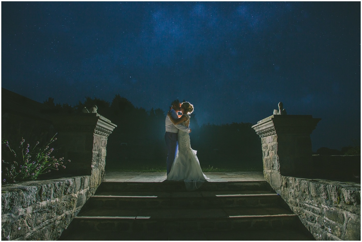 Bride and Groom lit from behind under a stary night sky