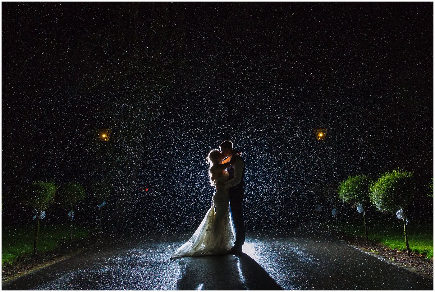 Bride and Groom kiss in the rain at Bartle Hall