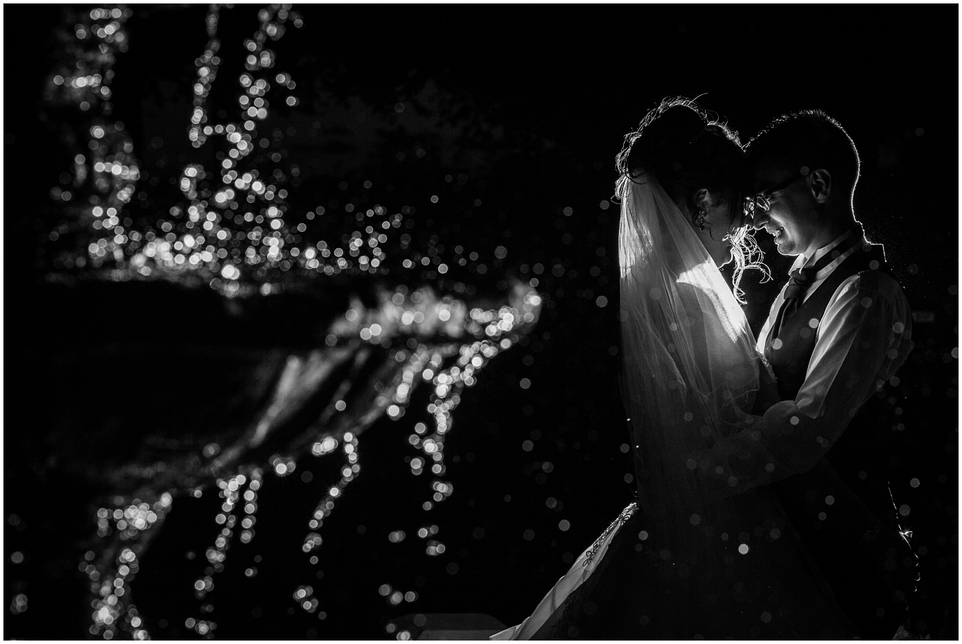 bride and groom in black and white share a moment by a fountain
