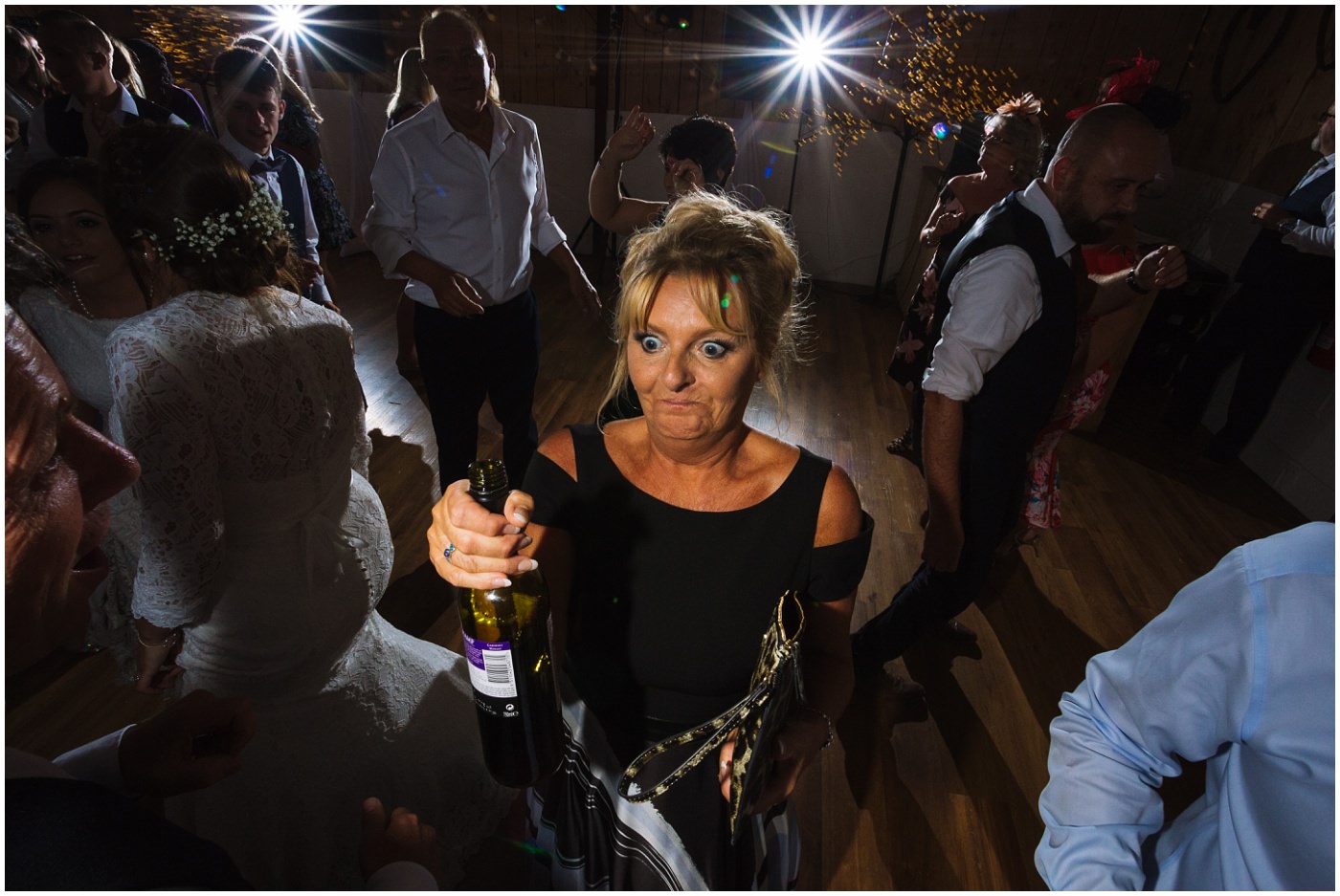 Mother of the bride with a bottle of wine on the dance floor