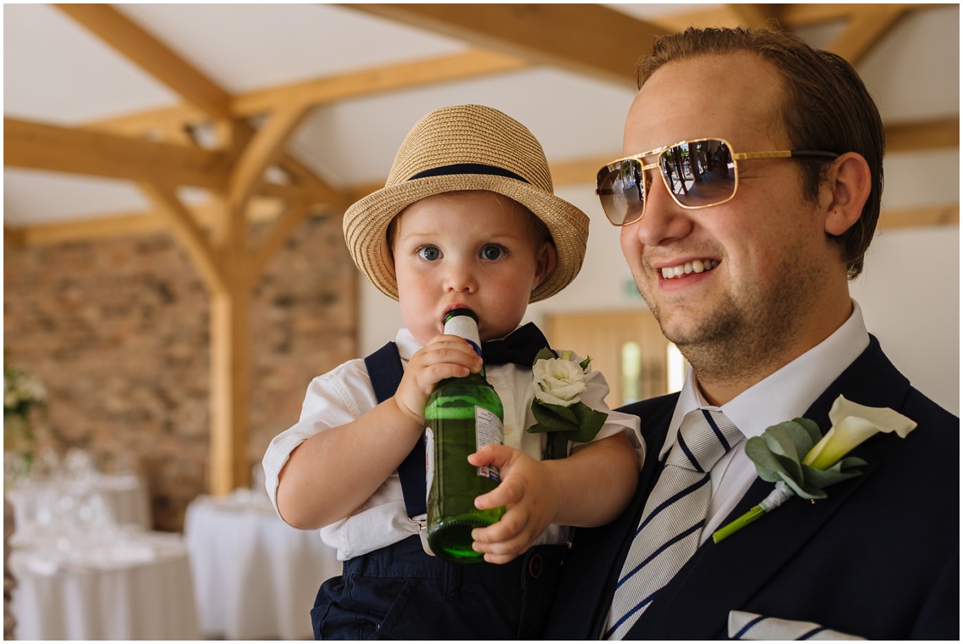 wedding guest holding a child with a beer