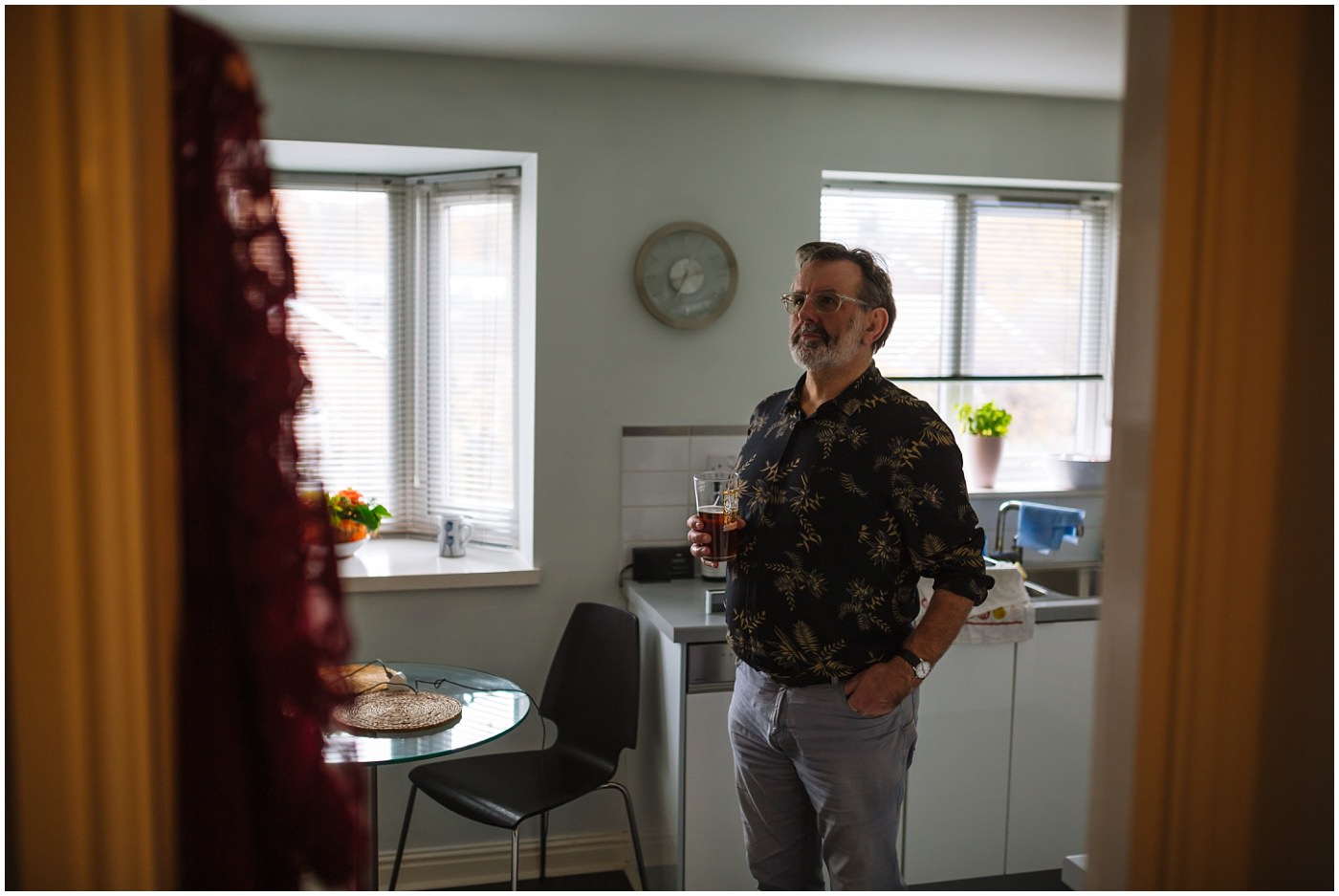 father of the bride stands in kitchen with beer
