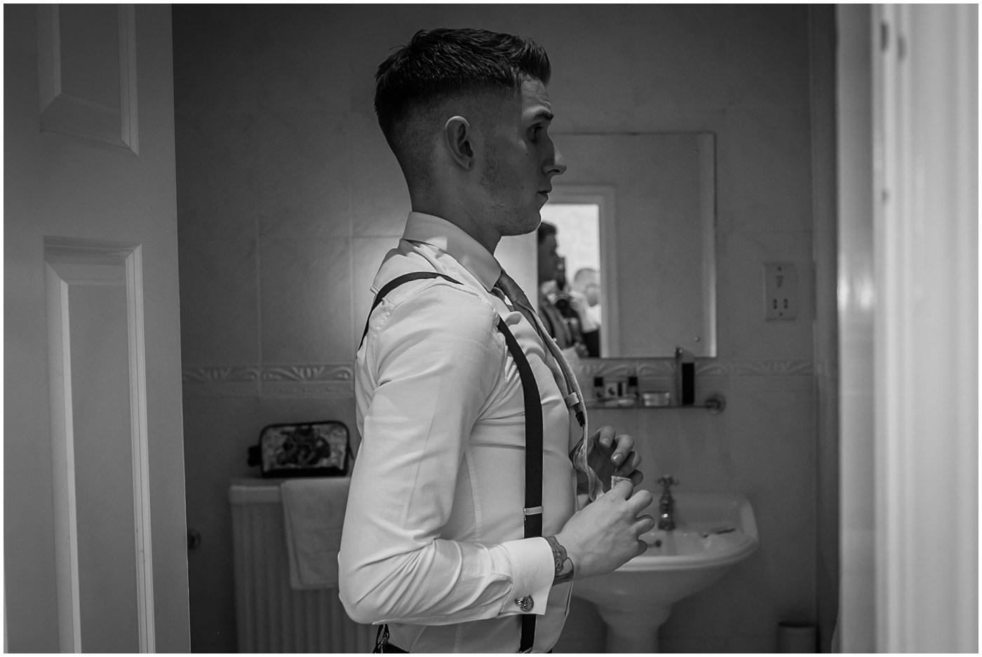 groom straightens his tie