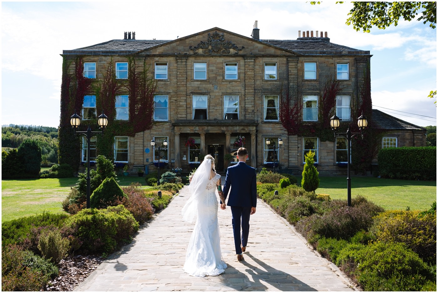 couple walk towards walton hall at waterton park