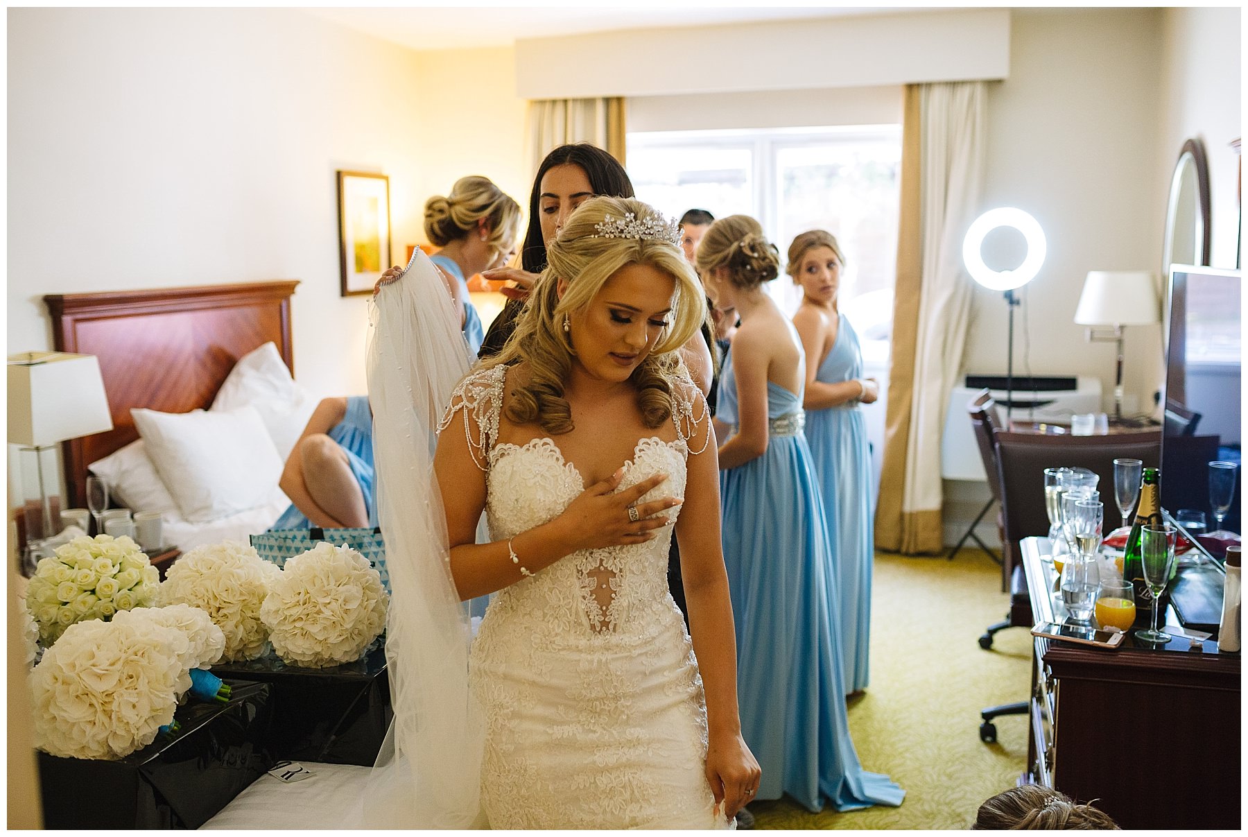 bride in wedding dress has finishing touches applied
