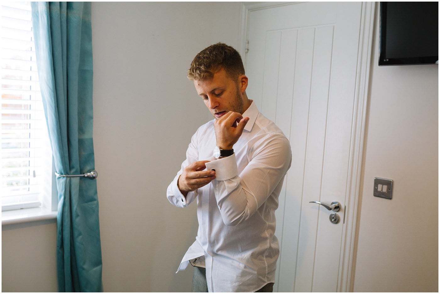 groom fixes his cufflinks