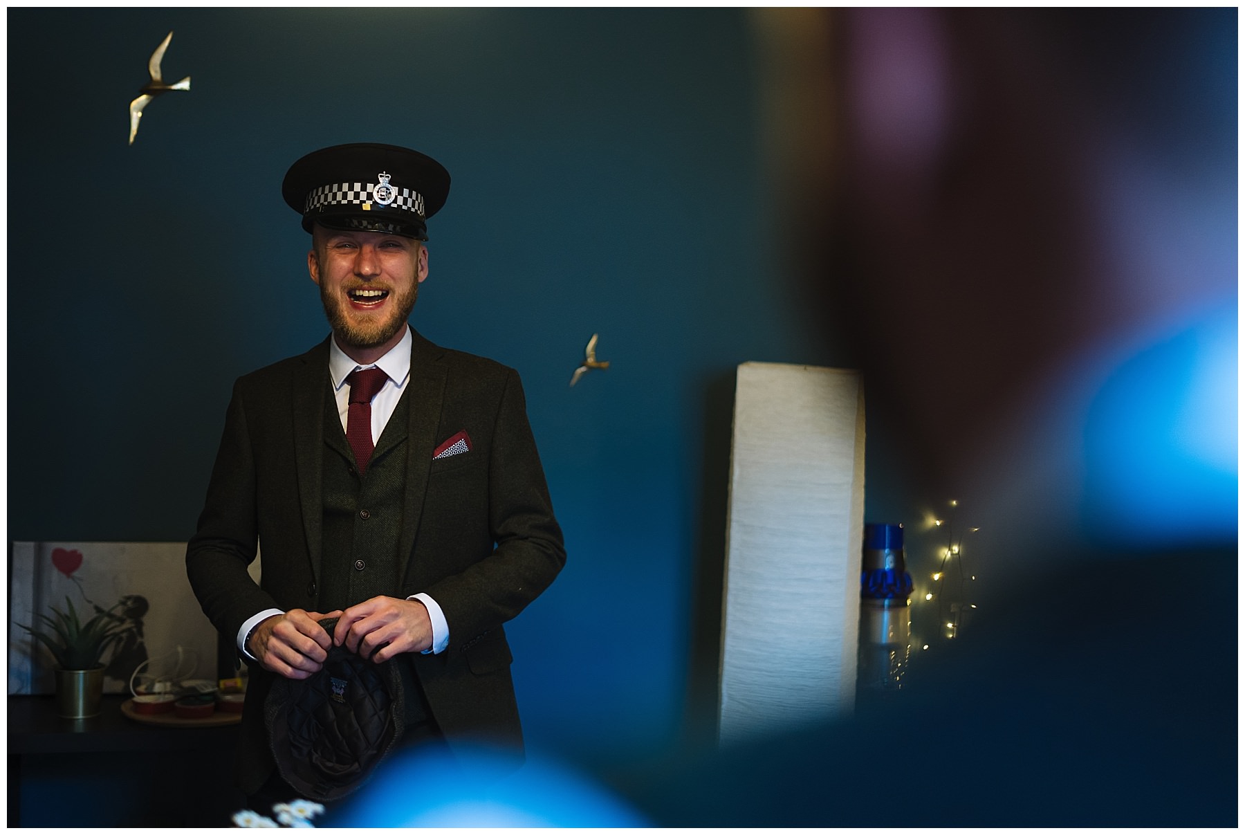 groom laughing wearing police hat