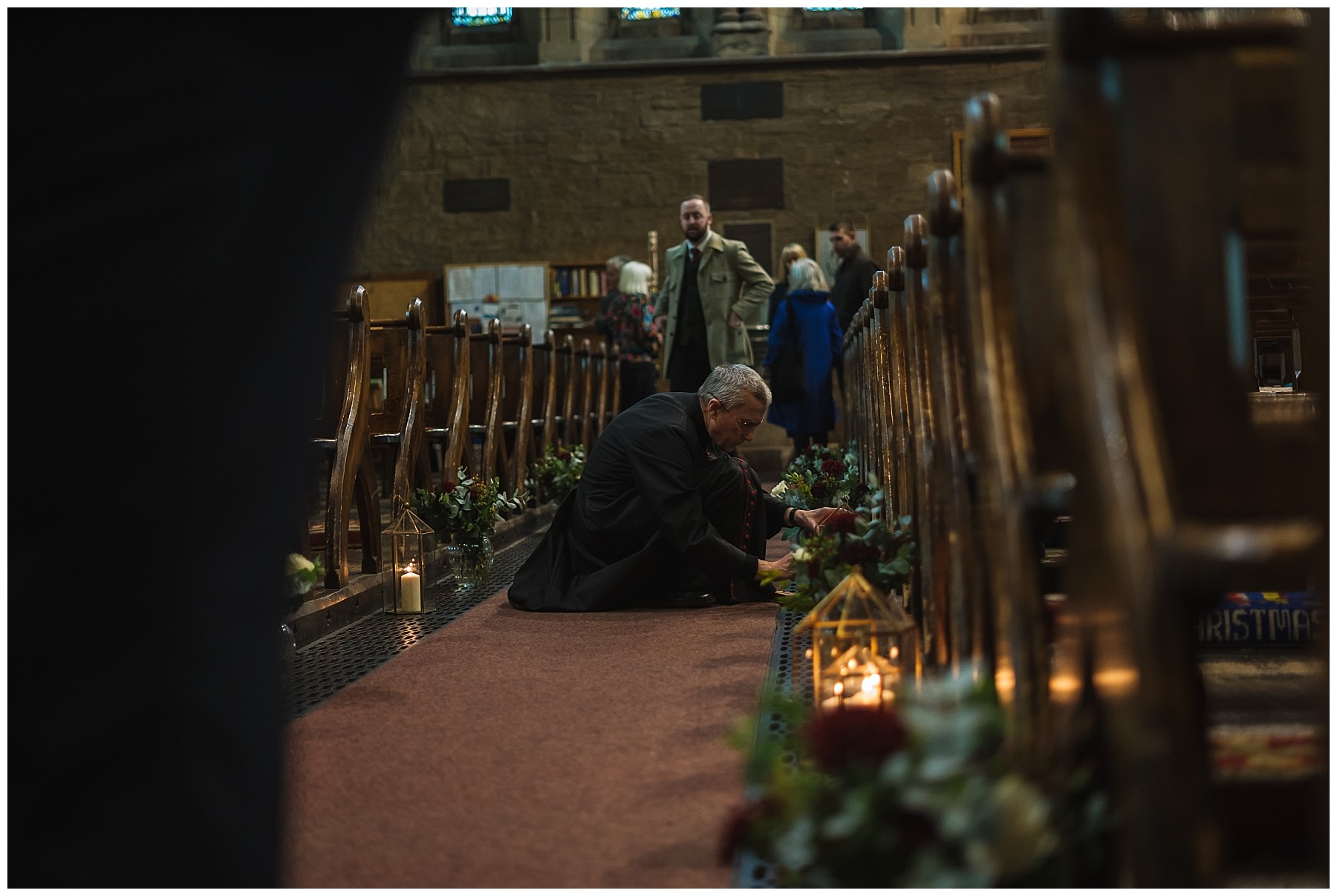 priest lighting candles in church