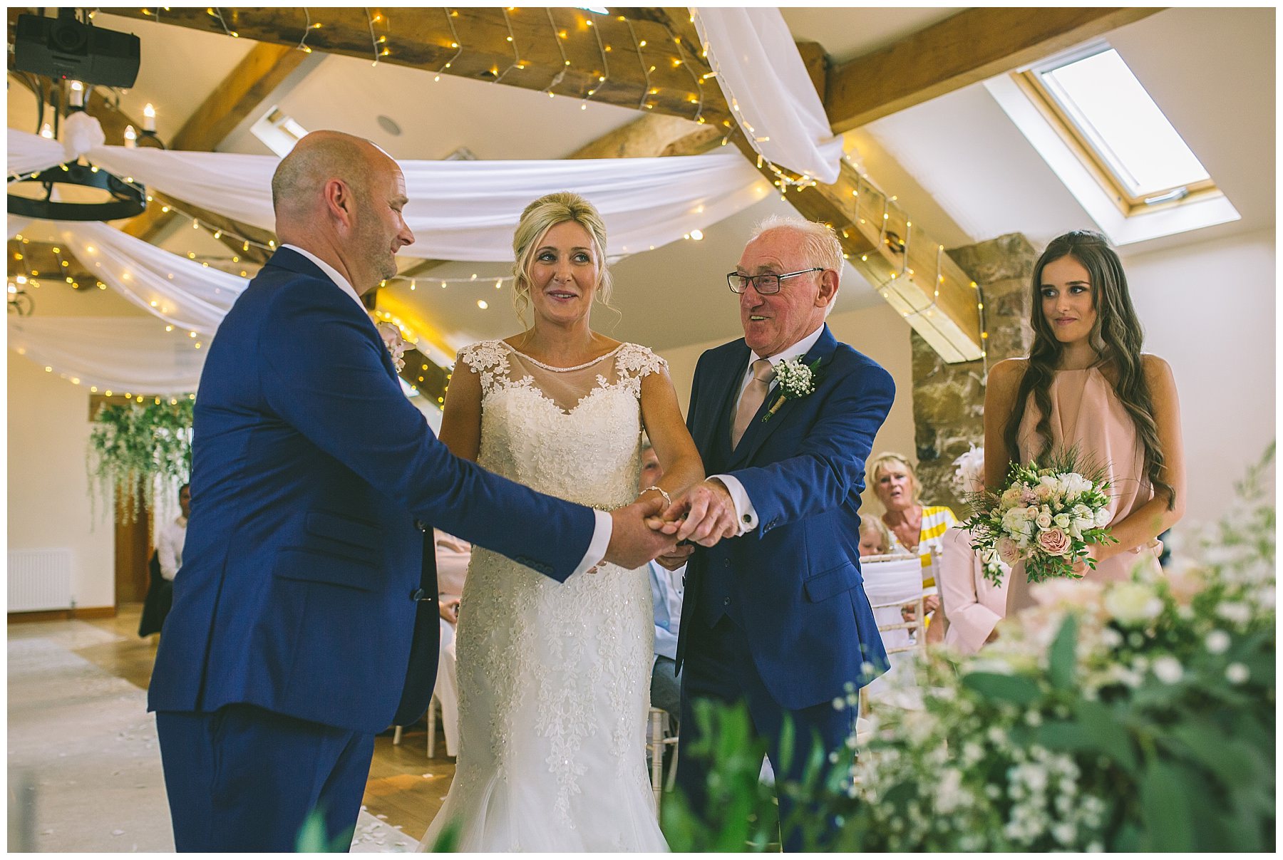 father of the bride passes daughters hand to her husband