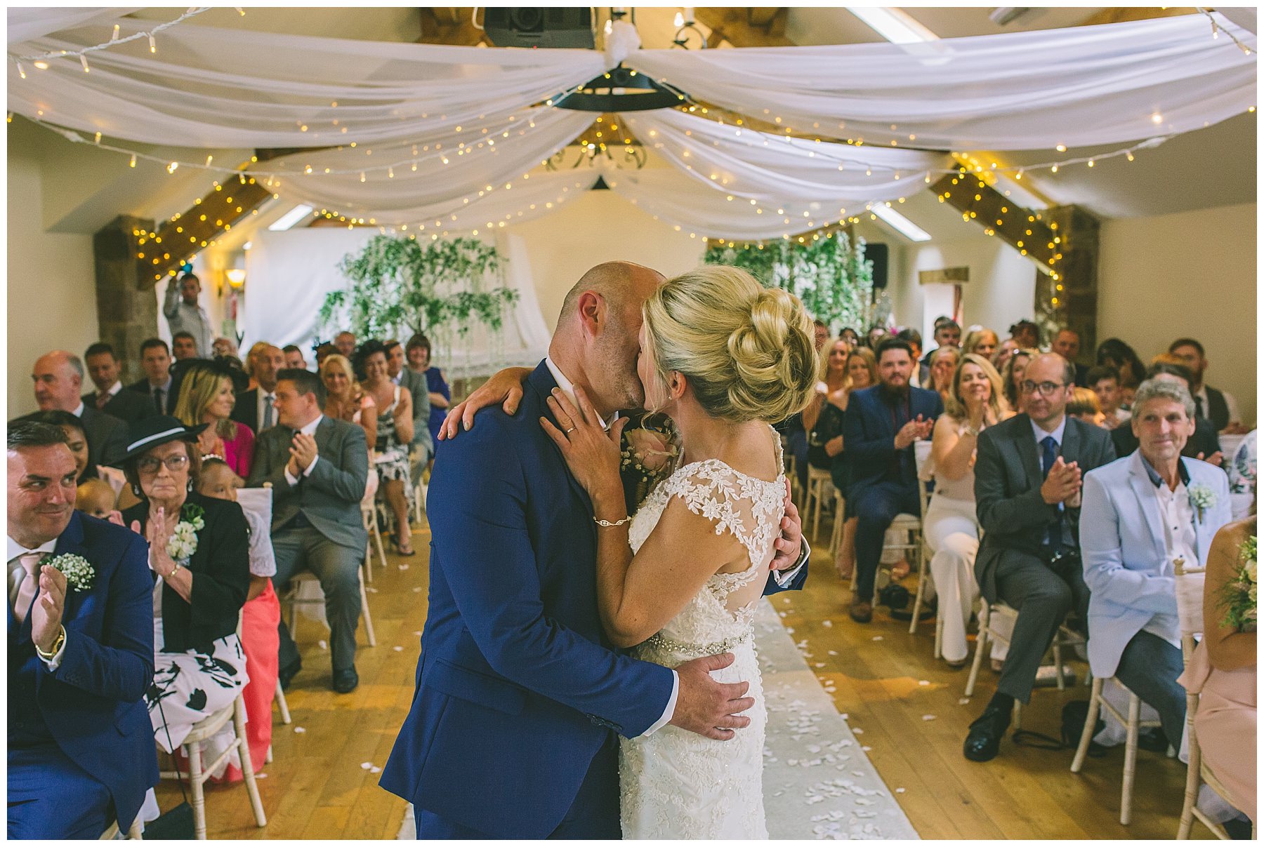bride and grooms first kiss in beeston manor ceremony room