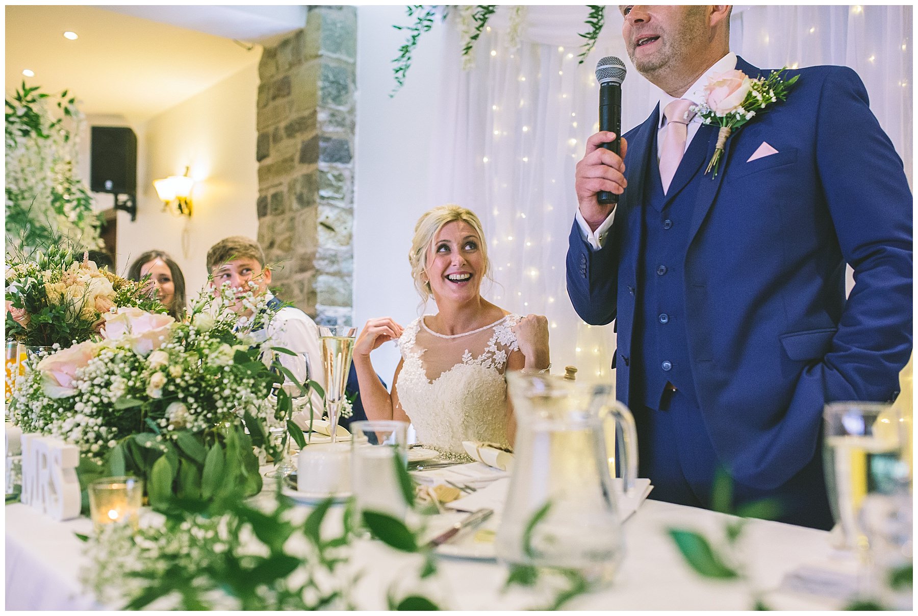 bride watches on as her husband address' wedding guests