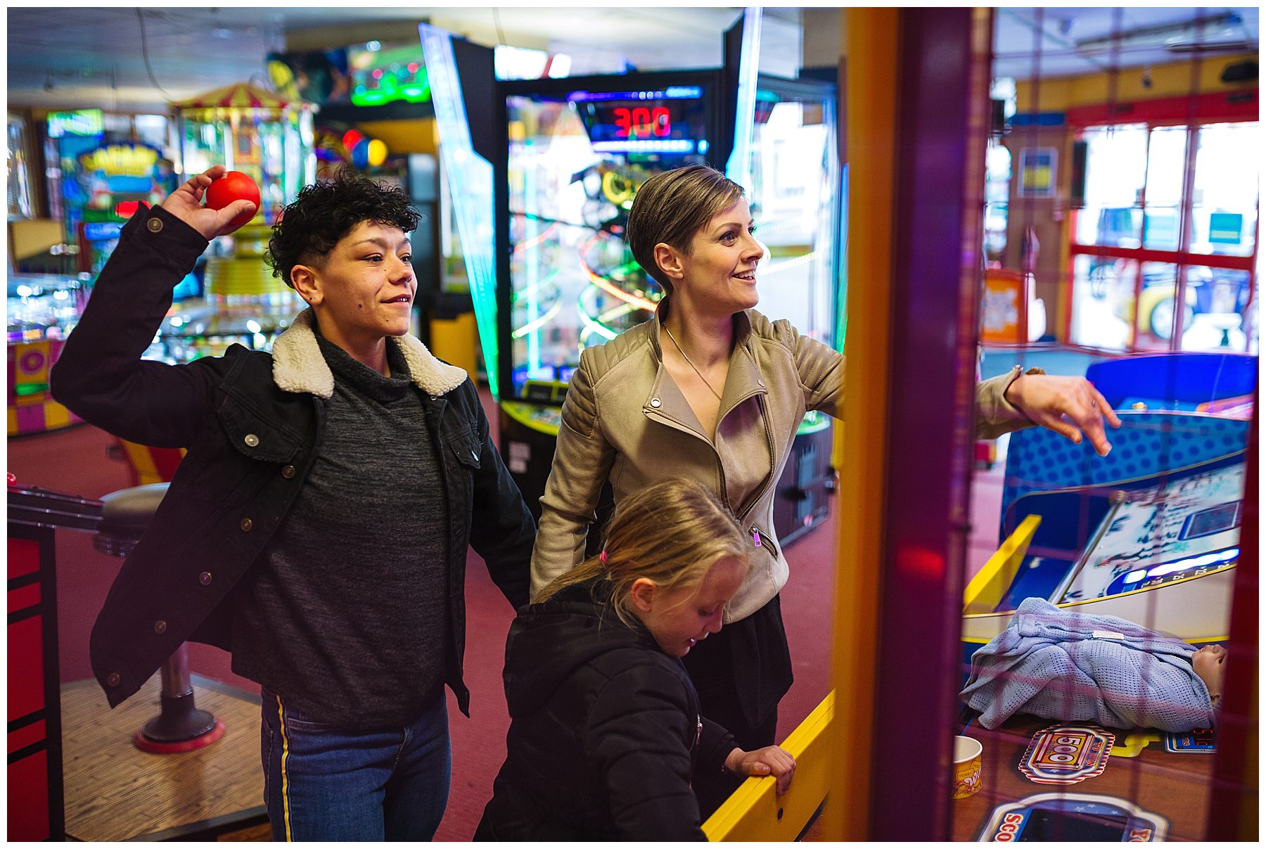 Couple and daughter enjoy arcades on the pier