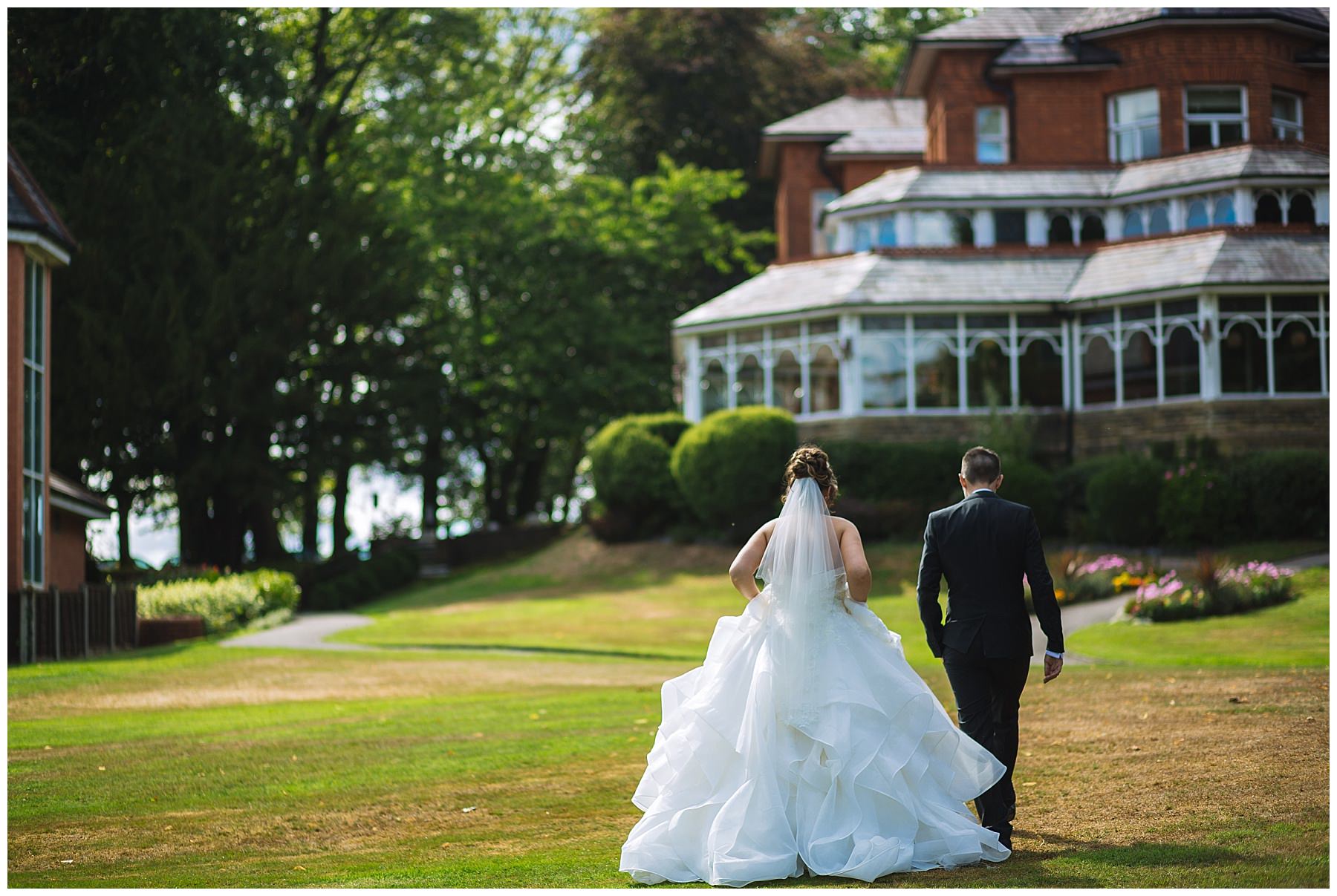 Married couple walk through the grounds of Kilhey Court