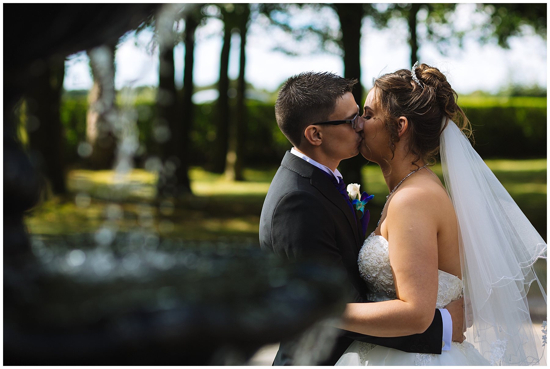 wedding couple kiss in front of fountain at kilhey court