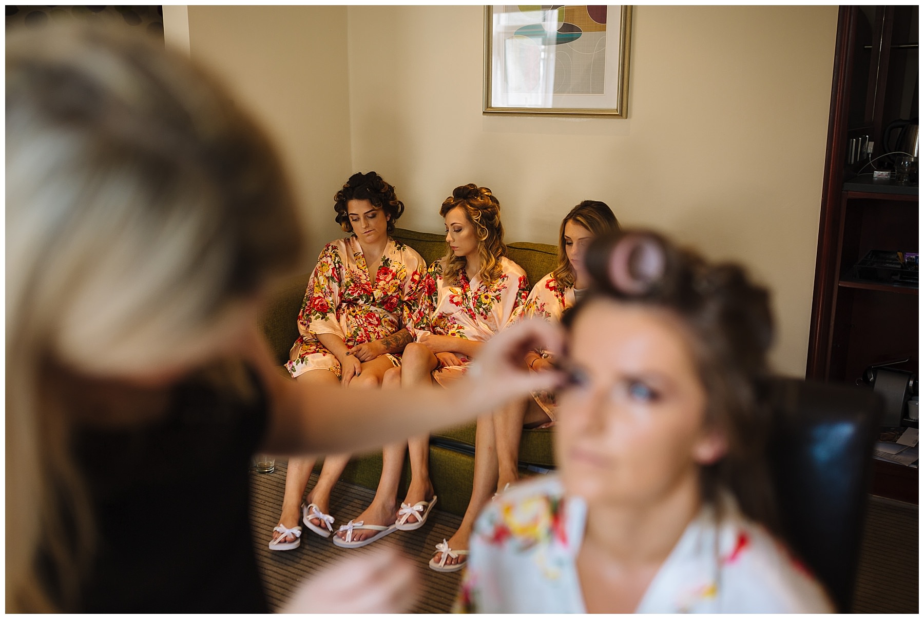 Bridesmaids wait while bride has make up applied