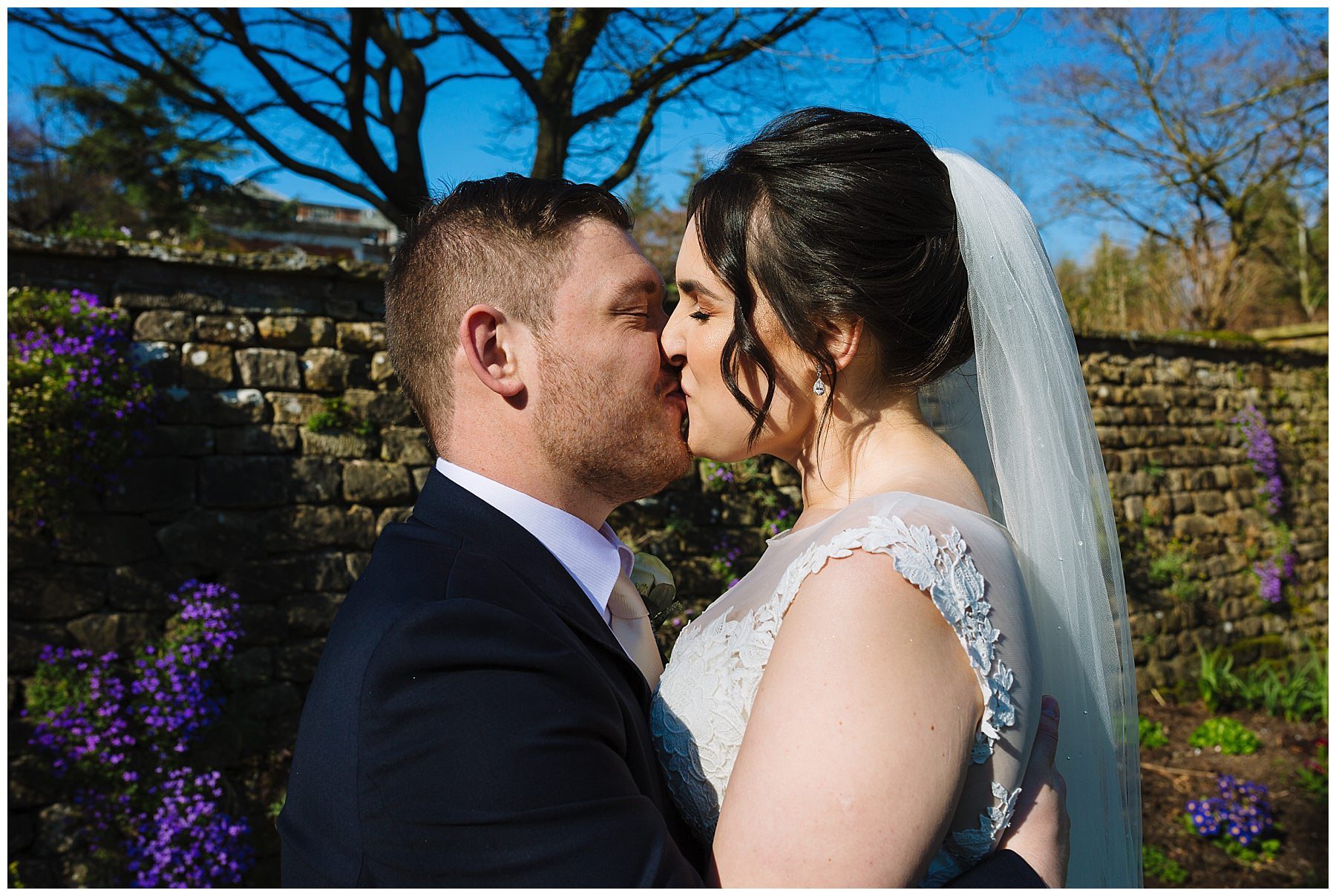 bride and groom kiss in the gardens at Eaves Hall