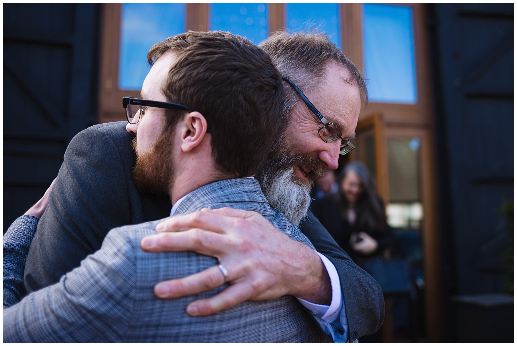 Father of the bride hugs groom after wedding ceremony