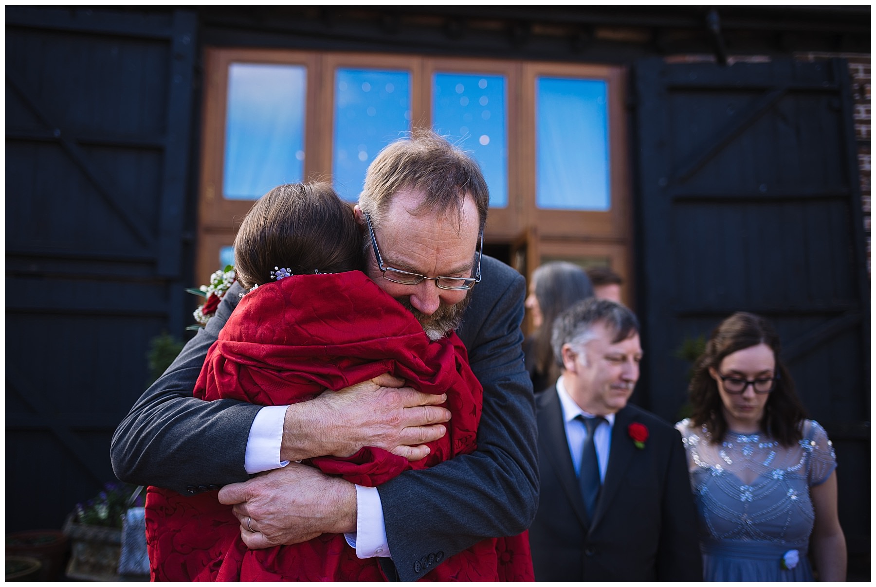 Father hugs bride after wedding ceremony