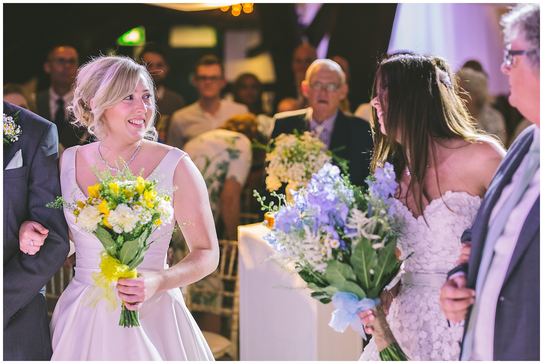 two brides meet at the top of the isle for same sex wedding