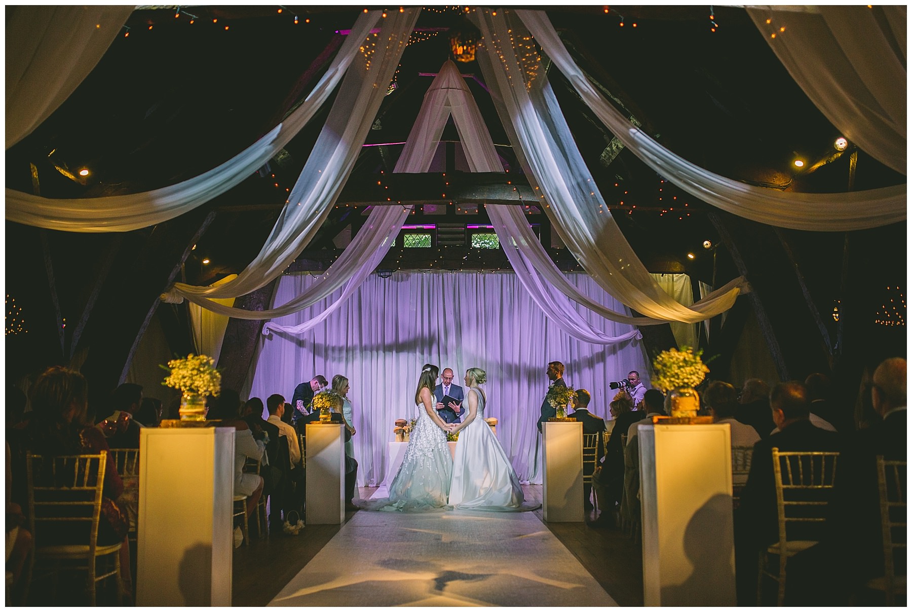 Two brides face each other as they say their vows during same sex wedding