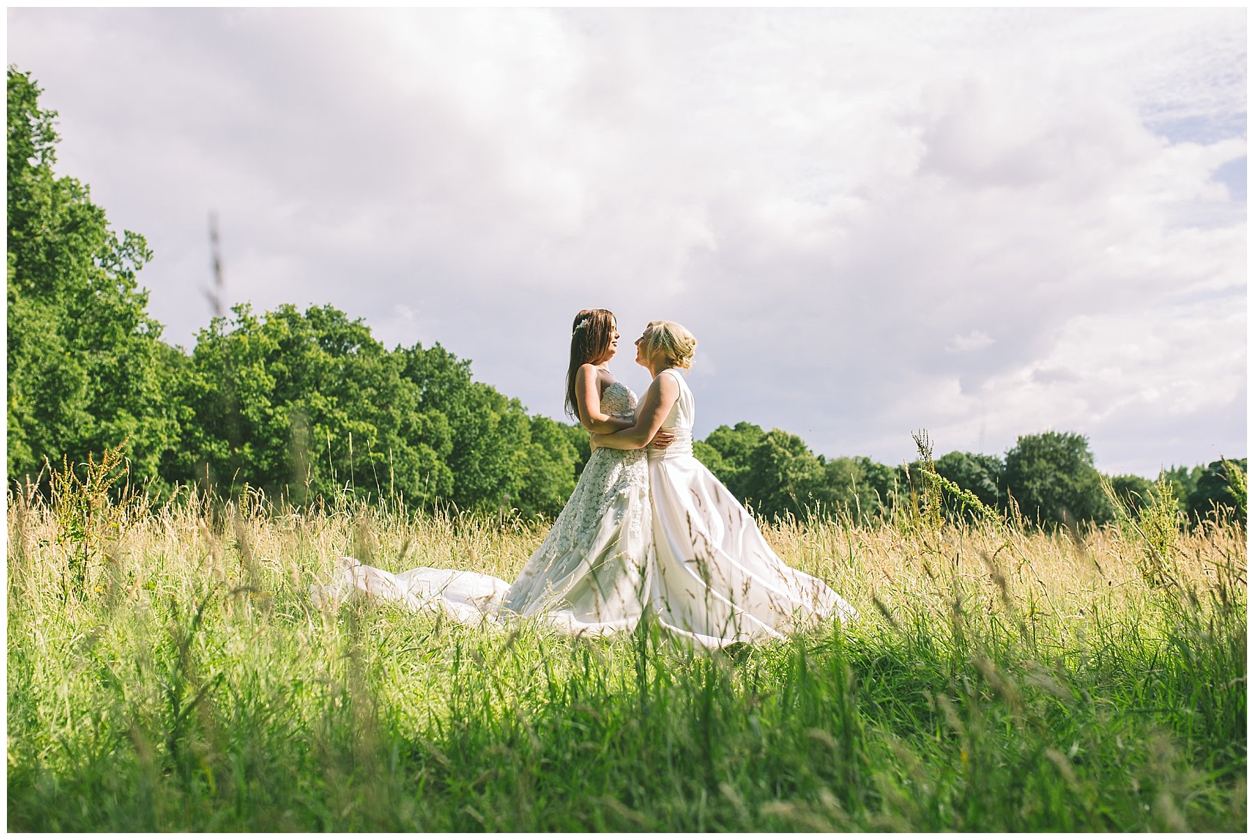 two brides in long grass at wedding venue