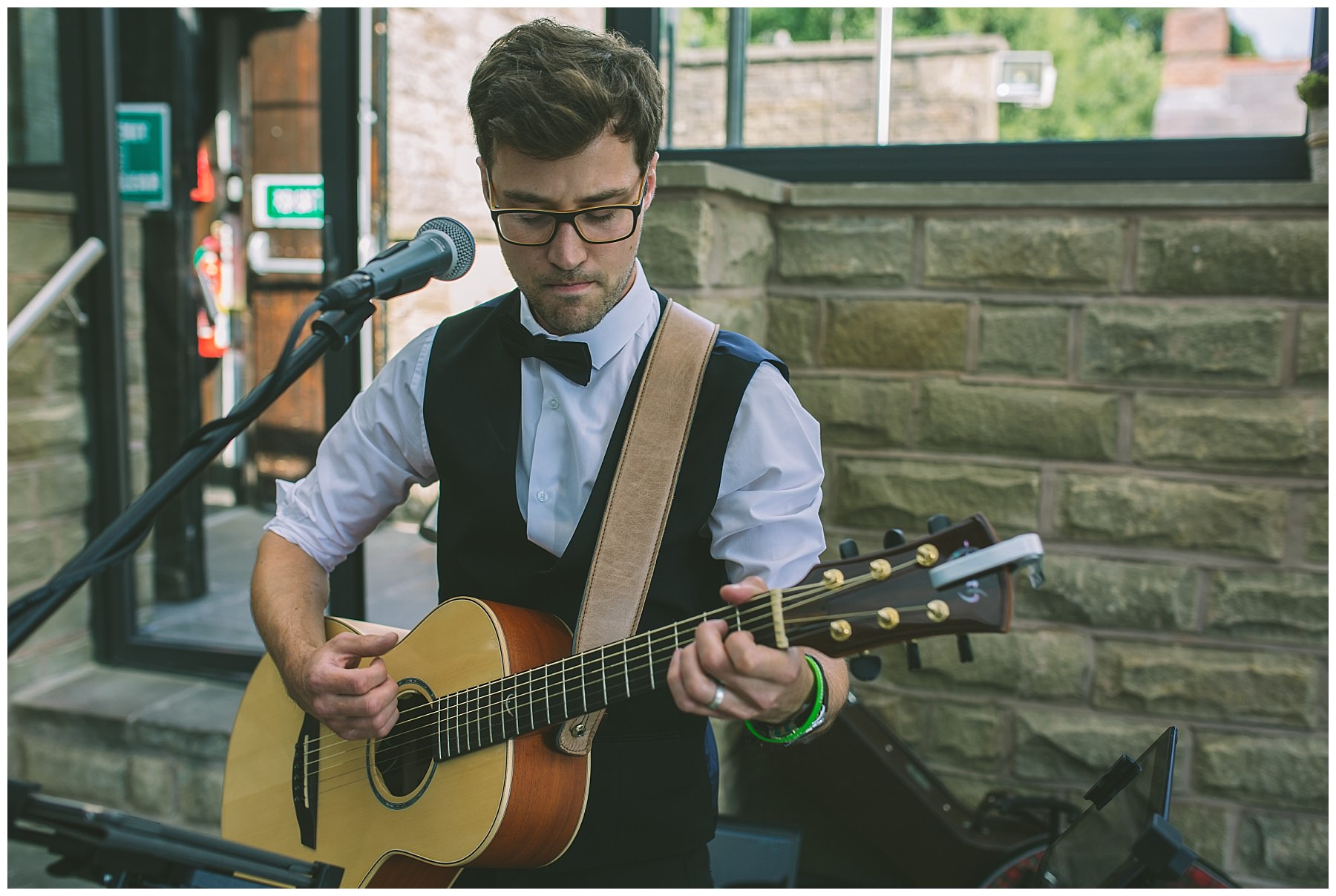 acoustic guitarist entertains wedding guests at rivington barn