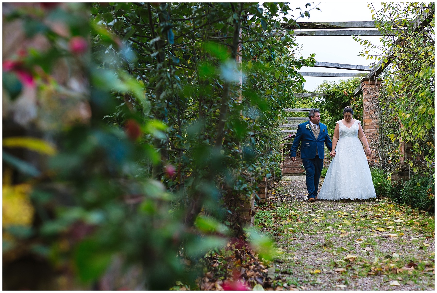 married couple walk through the gardens at willington hall