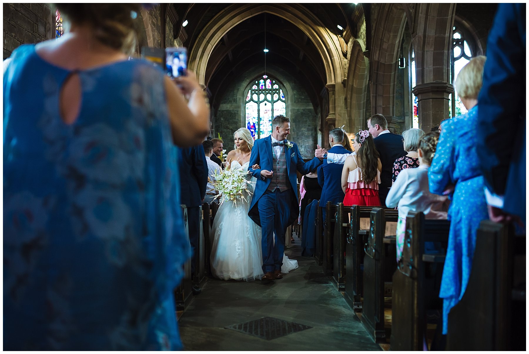 bride and groom exit church to applause